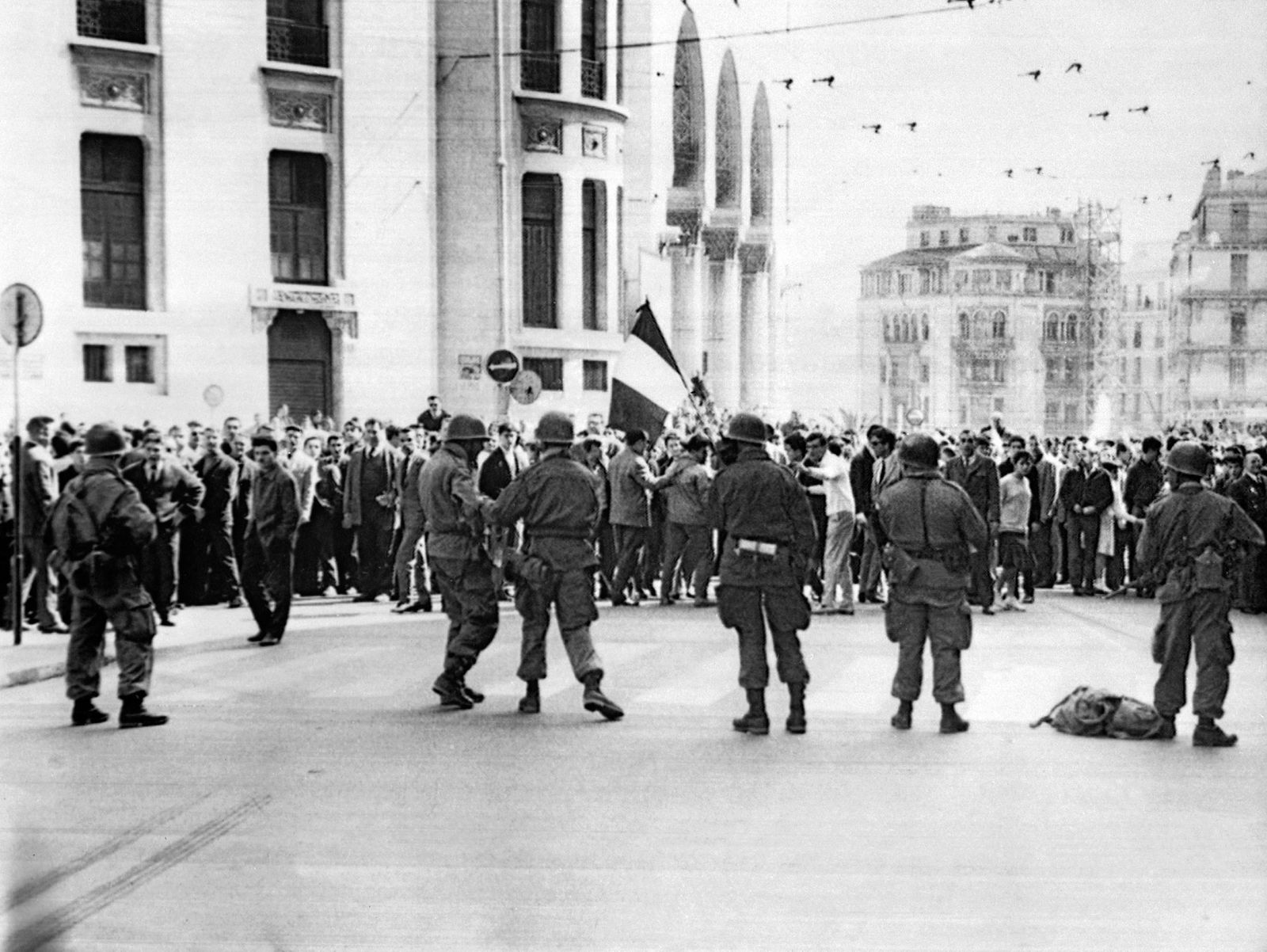 (FILES) In this file photo taken on March 26, 1962, French army soldiers and tirailleurs from the 4th Algerian Tirailleurs Regiment (RTA), face European protesters opposed to the independence of Algeria, in front of the Post of the rue d'Isly in Algiers, at a demonstration called by the Secret Armed Organization (OAS), during which the forces of the order opened fire on the demonstrators, killing more than dozens. - The Evian Accords were signed on March 18, 1962, between France and the Provisional Government of the Algerian Republic (GPRA), the government-in-exile of the Algerian National Liberation Front (FLN), ending the Algerian War of 1954-1962 and pathing the way for Algeria's Independence from France. (Photo by AFP) - AFP