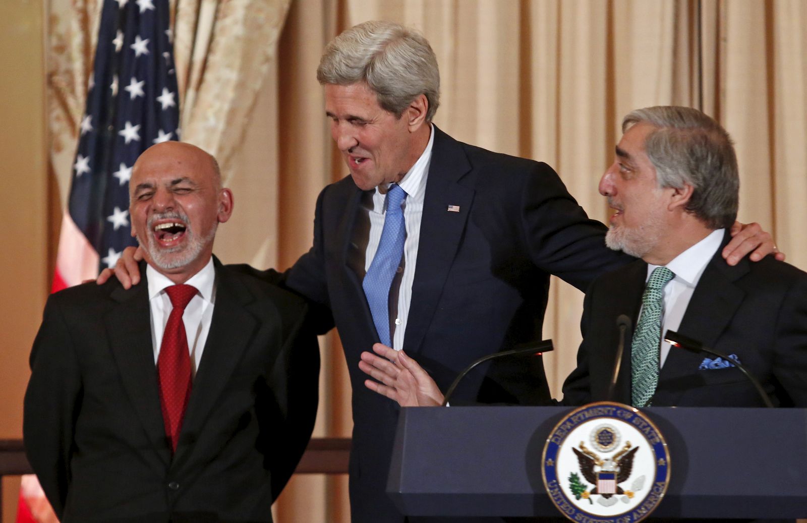 وزير الخارجية الأميركي السابق جون كيري متوسطاً الرئيس الأفغاني السابق أشرف غني (يسار) والرئيس التنفيذي عبد الله عبد الله في واشنطن - 24 مارس 2015 - REUTERS