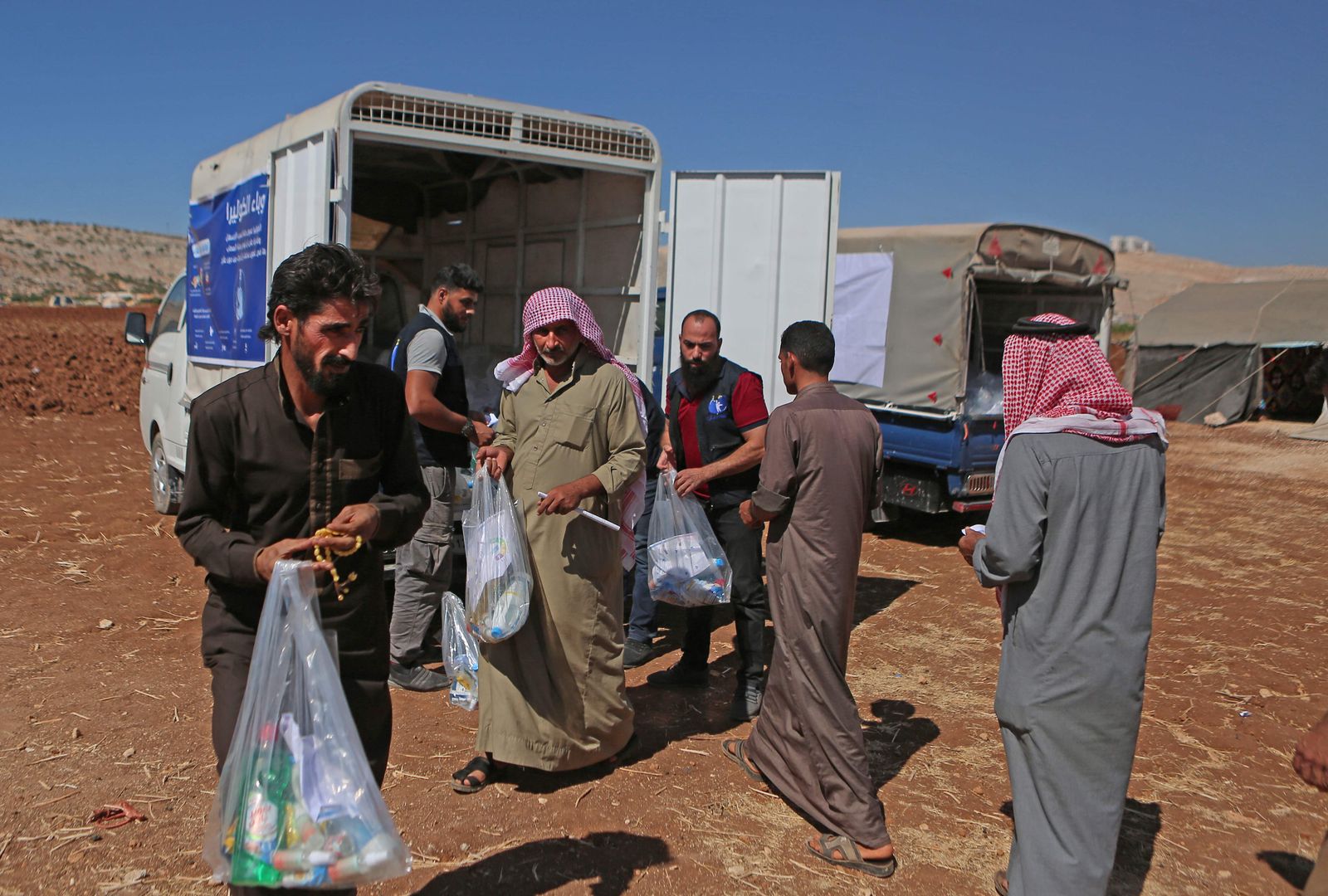 Syrians collect cleaning products distributed by a non-profit organisation at a camp for internally displaced people in the town of Sarmada in Syria's northwestern Idlib province on September 25, 2022 as part of an awareness campaign about hygiene in a bid to stem an outbreak of cholera. - Cholera is generally contracted from contaminated food or water and spreads in residential areas that lack proper sewerage networks or mains drinking water.
The disease is making its first major comeback since 2009 in Syria, where nearly two-thirds of water treatment plants, half of pumping stations and one-third of water towers have been damaged by more than a decade of war, according to the United Nations. (Photo by Aaref WATAD / AFP) - AFP