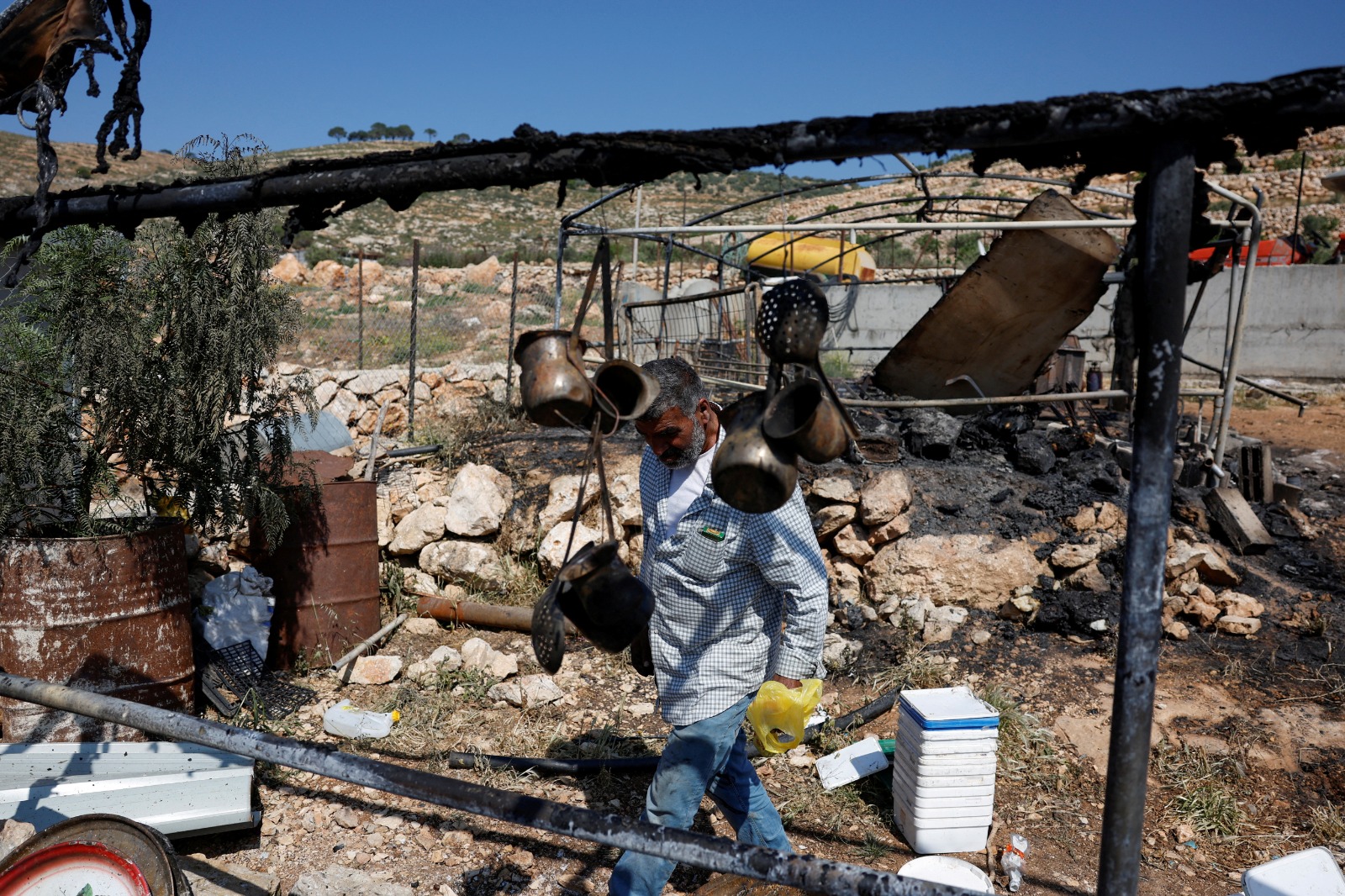 فلسطيني يتفقد الأضرار التي لحقت بمنزله بعد هجوم المستوطنين الإسرائيليين على قرية المغير في الضفة الغربية المحتلة. 13 أبريل 2024