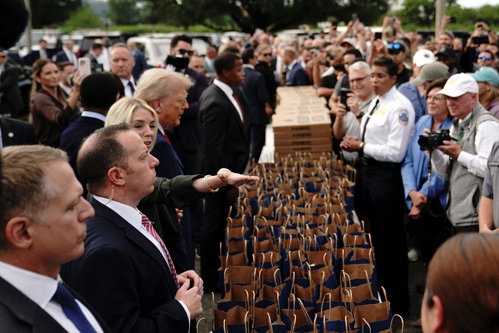 U.S. President Donald Trump and U.S. Attorney General Pam Bondi stand in front of a table with pizza boxes and paper bags, while they attend U.S. Park Police Anacostia Operations Facility to meet with police and the military, after Trump deployed National Guard troops in the nation's capital, in Washington, D.C., U.S., August 21, 2025.  REUTERS/Nathan Howard