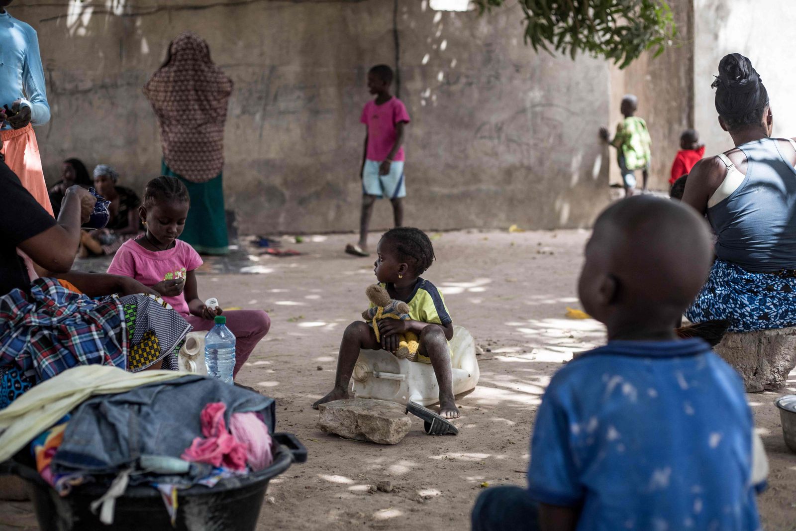 A young internally displaced girl holds onto her teddybear in the village of Bujinha on March 15, 2022. - On Sunday March 13, 2022, Senegal launched a military operation against the Movement of Democratic Forces of Casamance (MFDC) separatists along the border Senegal and Gambia displacing hundreds of Senegalese and Gambian families into Gambia. (Photo by MUHAMADOU BITTAYE / AFP) - AFP