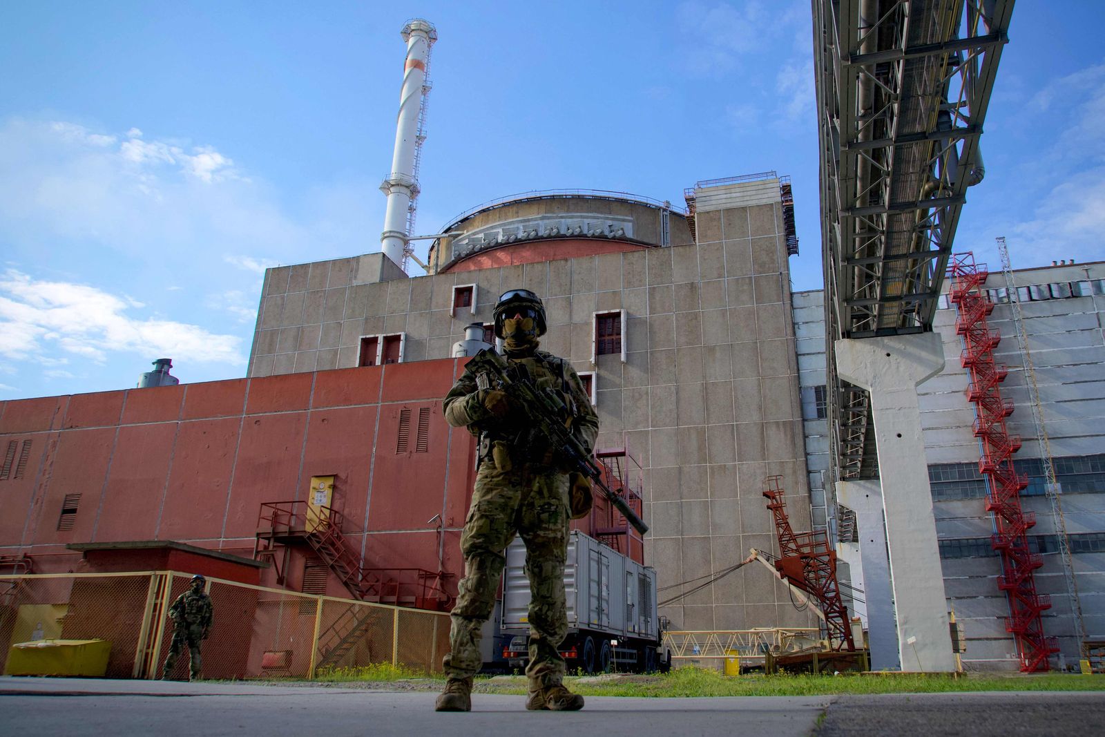 (FILES) In this file photo taken on May 01, 2022 a Russian serviceman stands guard at the territory outside the second reactor of the Zaporizhzhia Nuclear Power Station in Energodar. - Russia has hinted it is seeking to cut off Ukraine from Europe's largest nuclear plant unless Kyiv pays Moscow for electricity. The Zaporizhzhia plant was captured by Russian troops following President Vladimir Putin's special military operation in Ukraine launched on February 24. (Photo by Andrey BORODULIN / AFP) - AFP