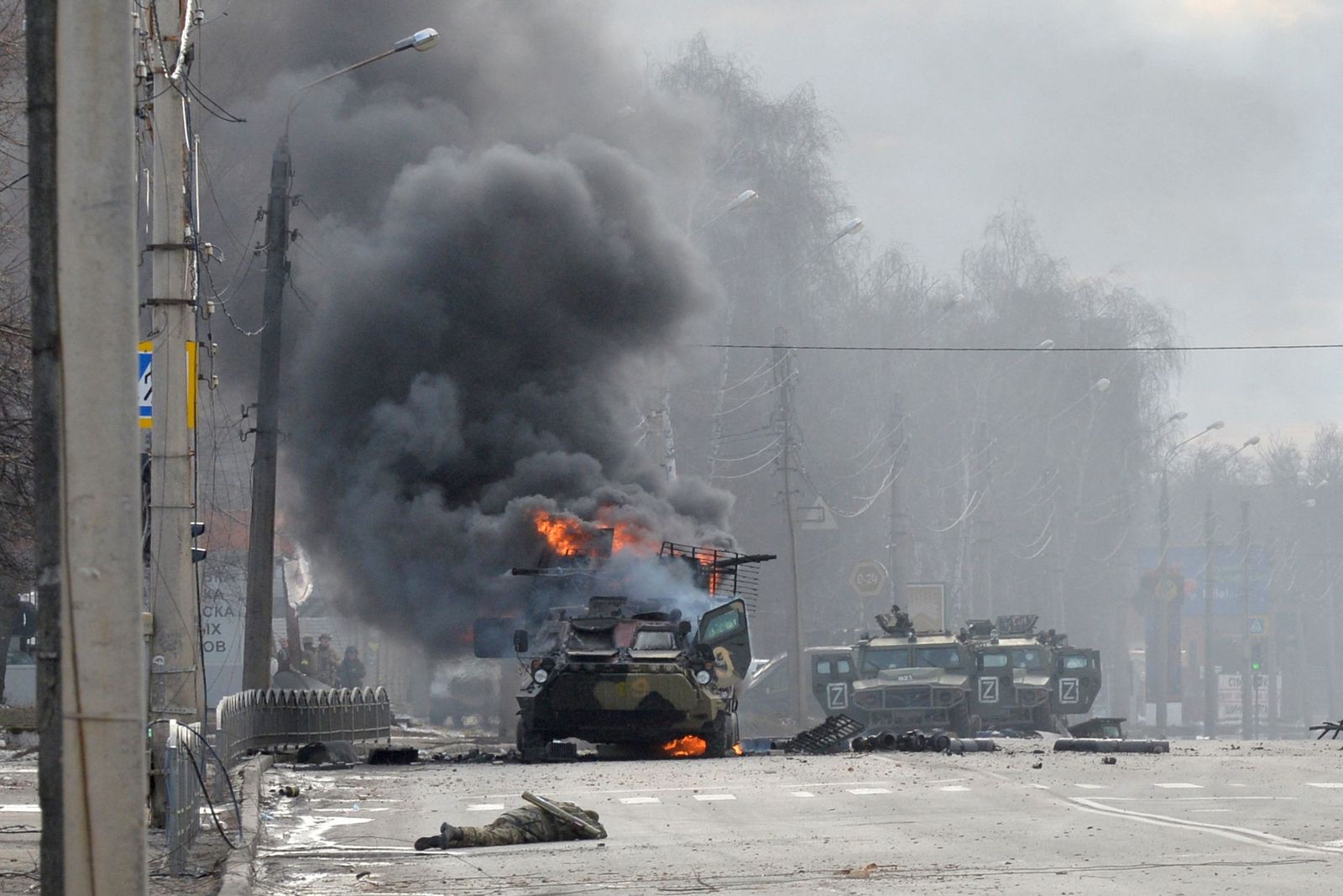 (FILES) An unidentified soldier's body lies near a burning Russian Armoured personnel carrier (APC) during fighting with the Ukrainian armed forces in Kharkiv, on February 27, 2022. Ukrainian forces secured full control of Kharkiv on February 27, 2022 following street fighting with Russian troops in the country's second biggest city, the local governor said. (Photo by Sergey BOBOK / AFP)