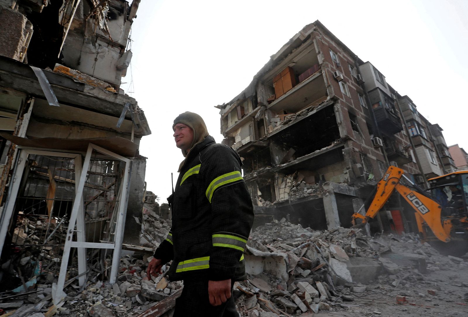 عامل إنقاذ يسير إلى جانب مبنى مدمر في مدينة ماريوبل الأوكرانية جراء القصف الروسي. 19 أبريل 2022 - REUTERS