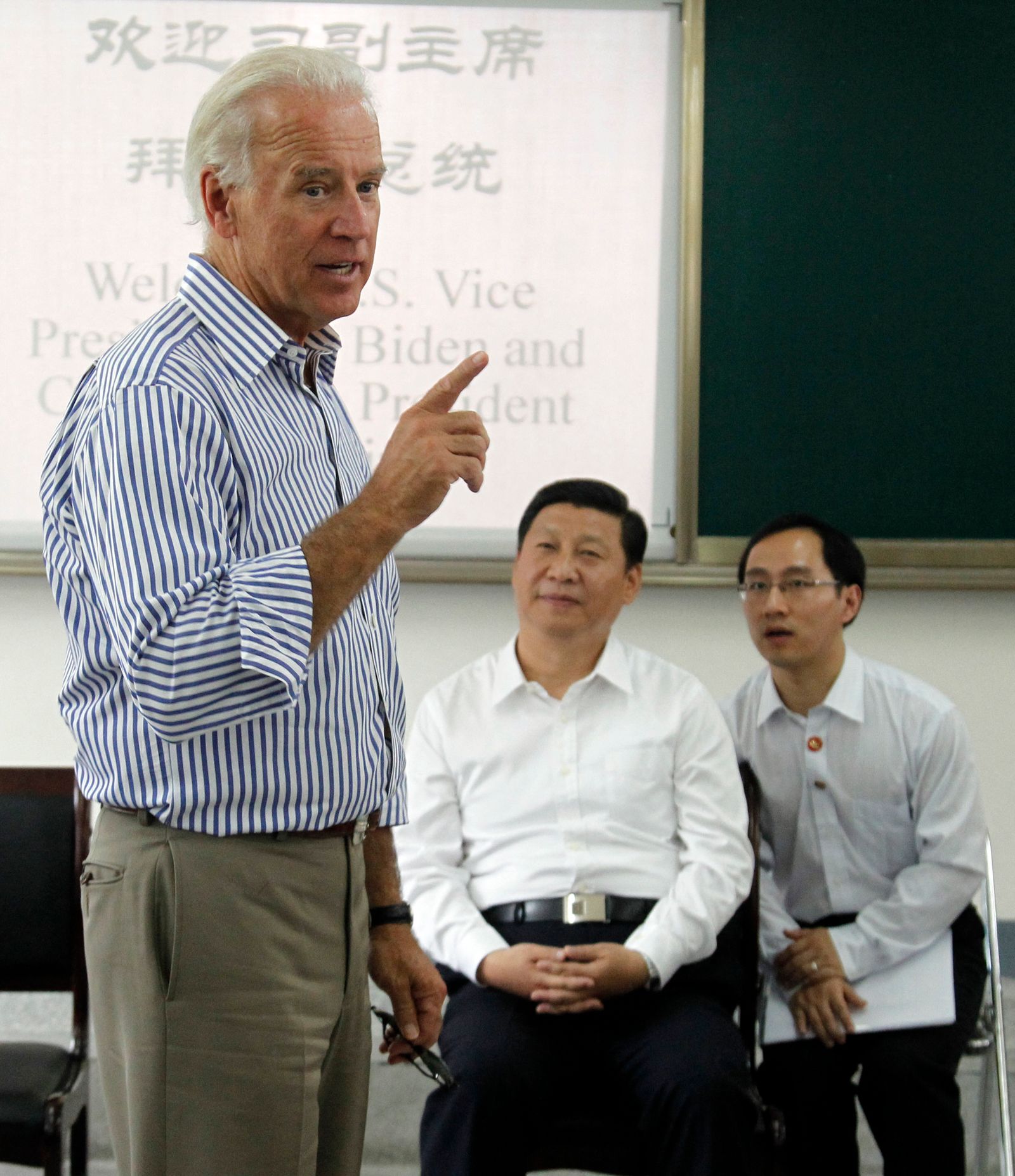 الرئيس الصيني شي جين بينج، حين كان نائباً للرئيس، يستمع إلى نظيره الأميركي جو بايدن، وكان نائباً للرئيس، خلال تحدثه إلى طلاب في مدرسة ثانوية بإقليم سيتشوان في الصين - 21 أغسطس 2011 - AFP