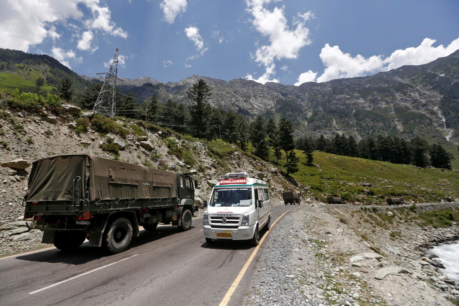 سيارة إسعاف تمرّ قرب قافلة للجيش الهندي على طريق يؤدي إلى منطقة لاداخ - 18 يونيو 2020 - REUTERS