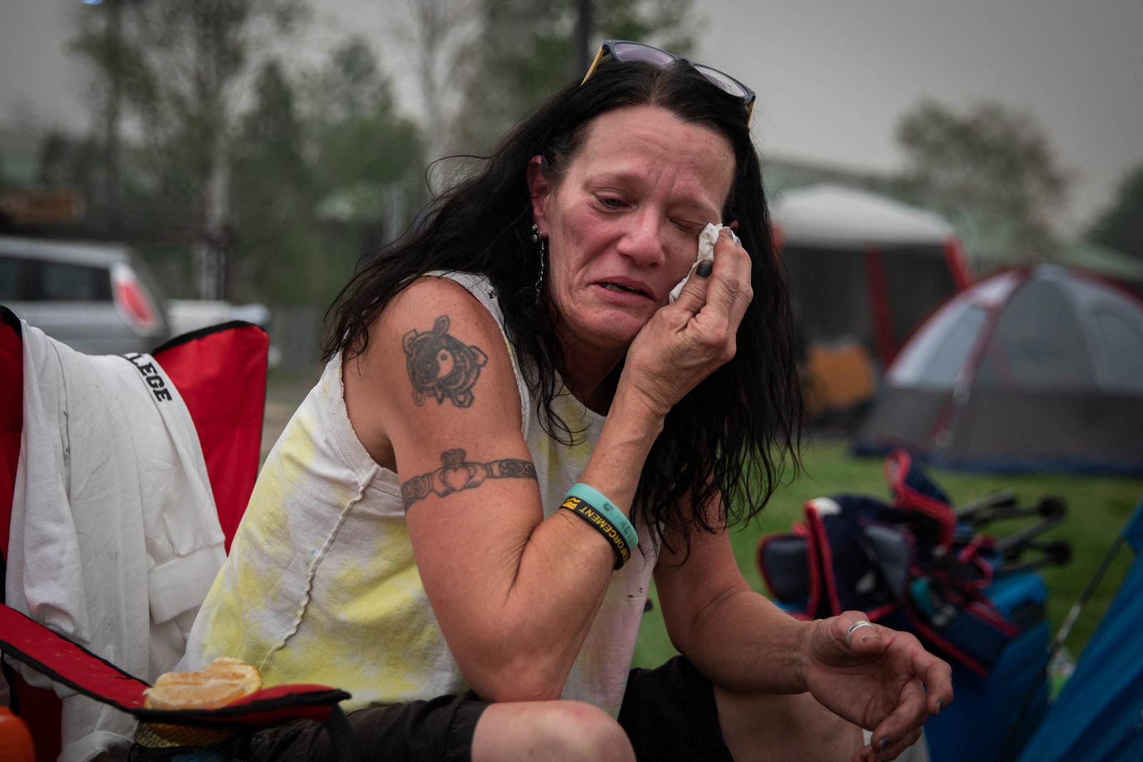 سيدة أميركية تمسح دموعها في مخيم لإيواء الفارين من حرائق ديكسي في سمرفيل بكاليفورنيا 7 أغسطس 2021 - Getty Images via AFP