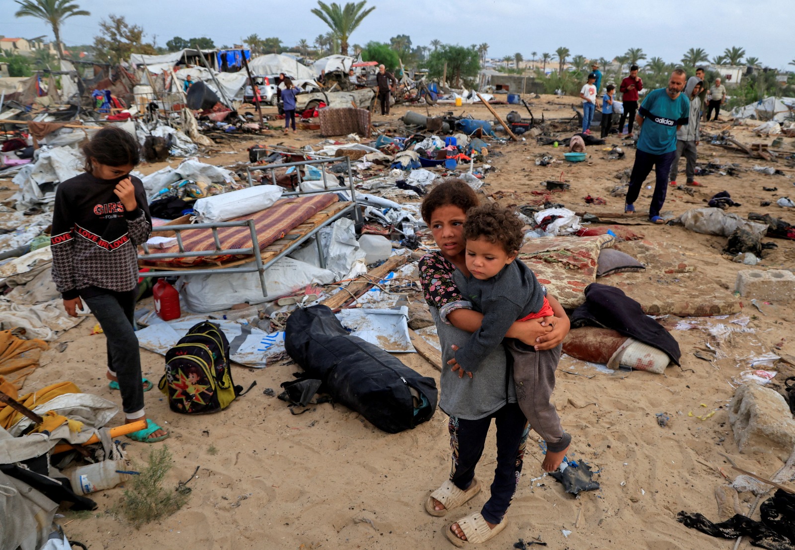 فلسطينيون يتفقدون الأضرار في موقع غارة إسرائيلية على مخيم للنازحين في خان يونس جنوب قطاع غزة. 18 مايو 2025