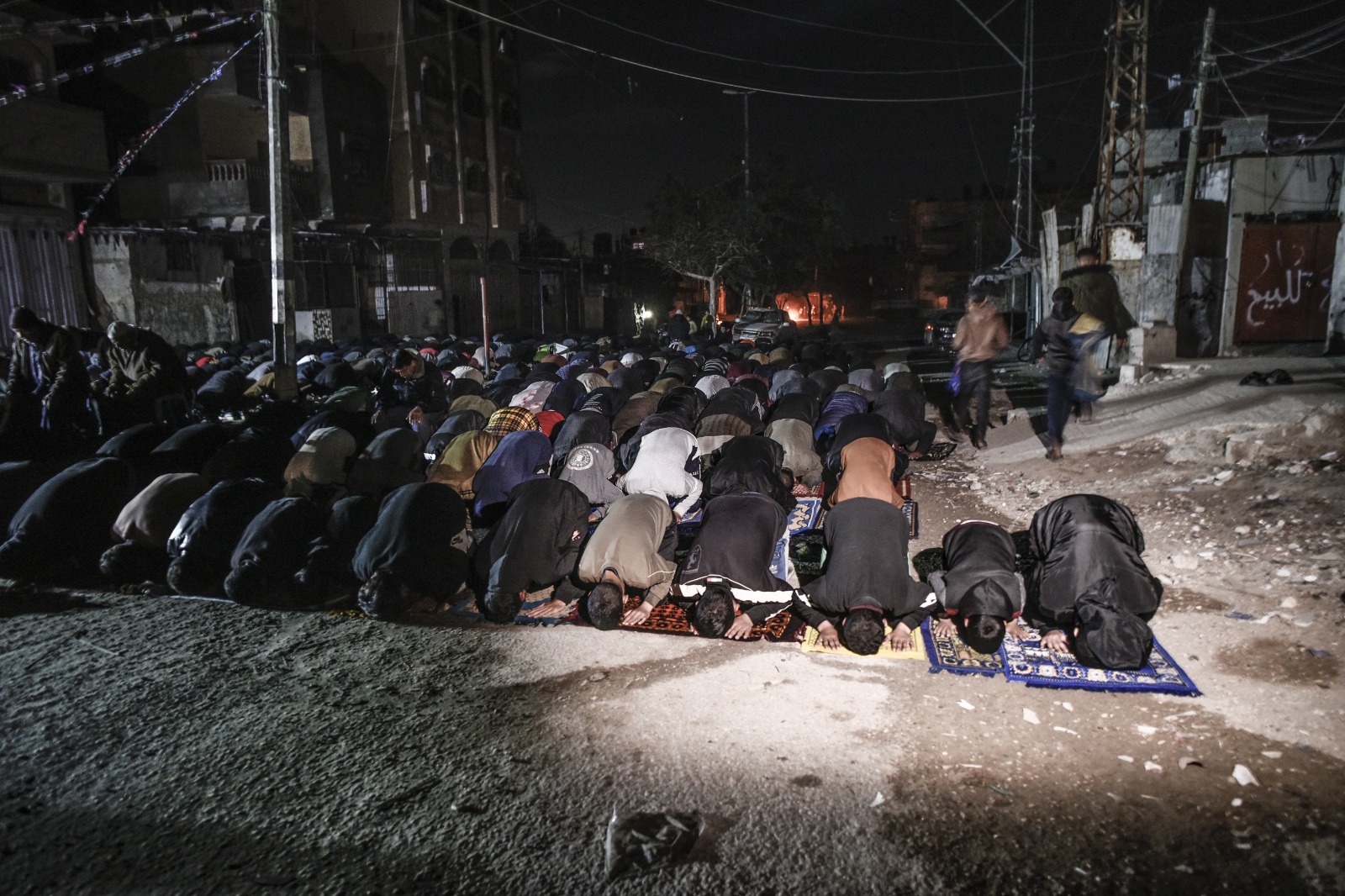 فلسطينيون يؤدون صلاة التراويح بمدينة رفح وسط آثار دمار الهجمات الإسرائيلية على قطاع غزة. 10 مارس 2024