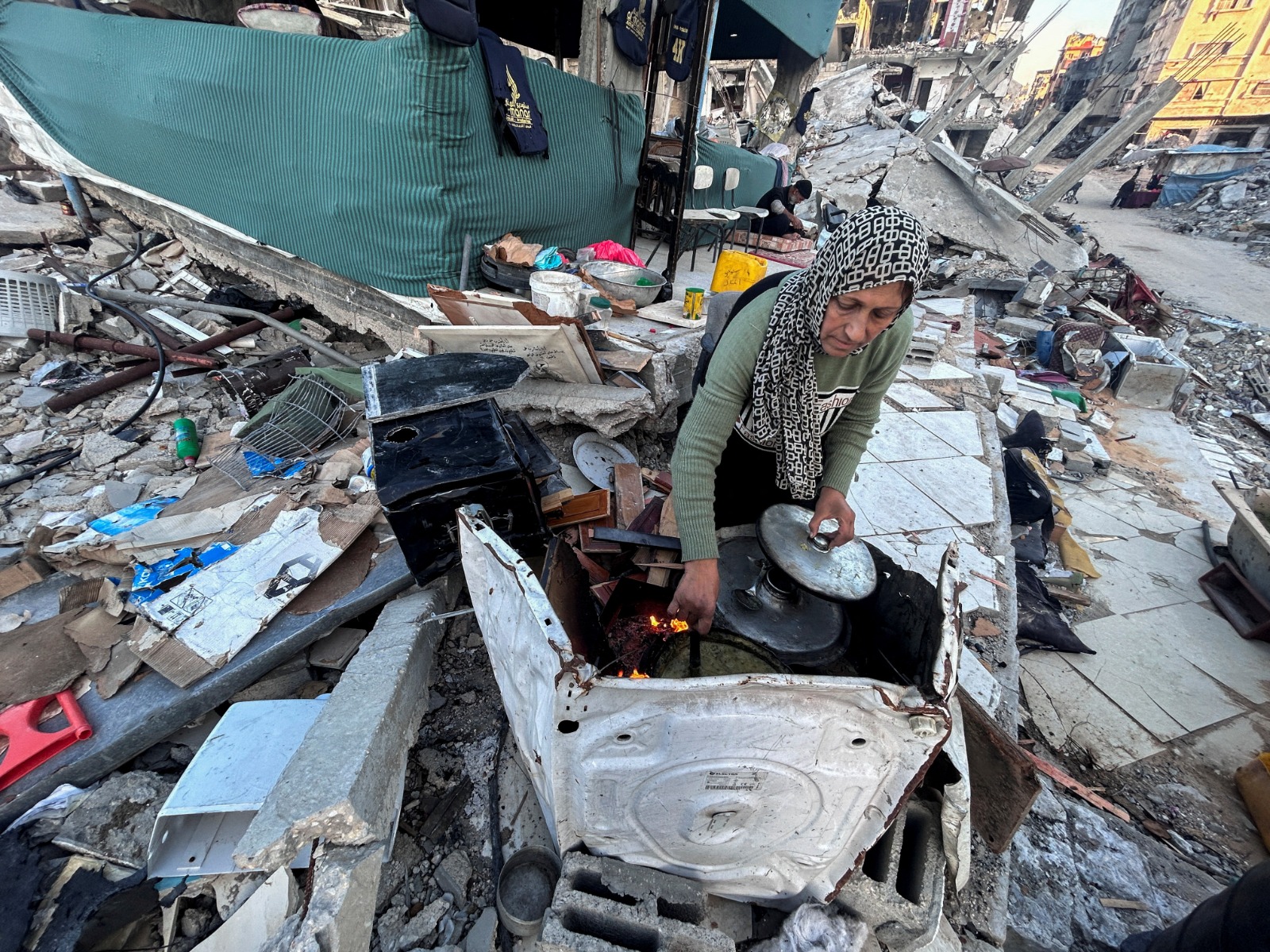 امرأة فلسطينية تجهز وجبة إفطار بين ركام منزل دمرته غارات إسرائيلية على بيت لاهيا شمال قطاع غزة. 14 مارس 2024