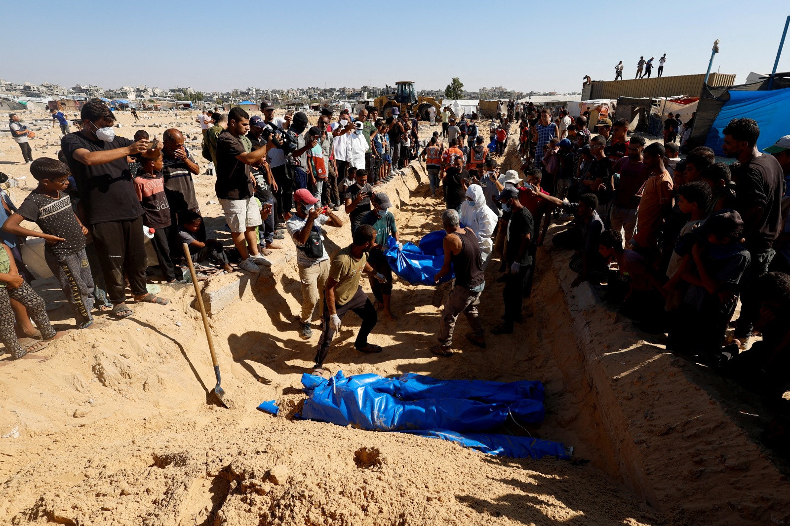 فلسطينيون يدفنون ذويهم ضحايا الغارات الإسرائيلية في مقبرة جماعية بخان يونس جنوبي قطاع غزة - REUTERS