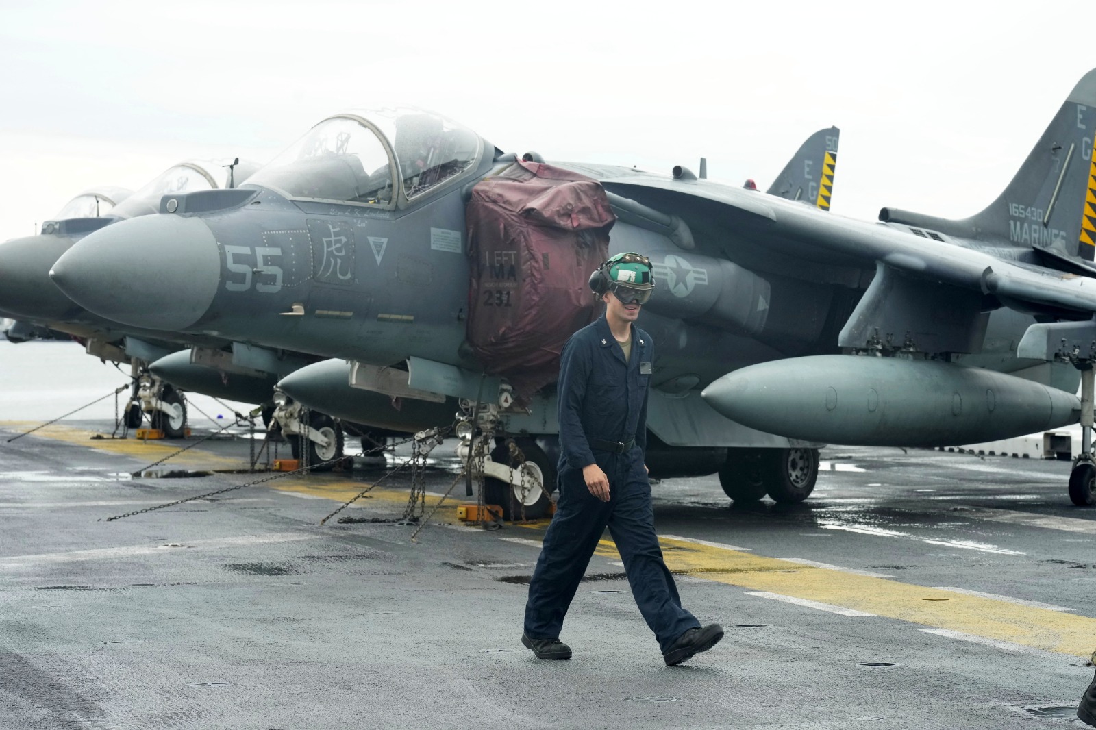 جندي من البحرية الأميركية يمر بجانب مقاتلات ماكدونيل دوجلاس AV-8B هاريير 2 على متن سفينة الهجوم البرمائية من فئة واسب التابعة للبحرية الأميركية في ليتوانيا. 22 أغسطس 2022