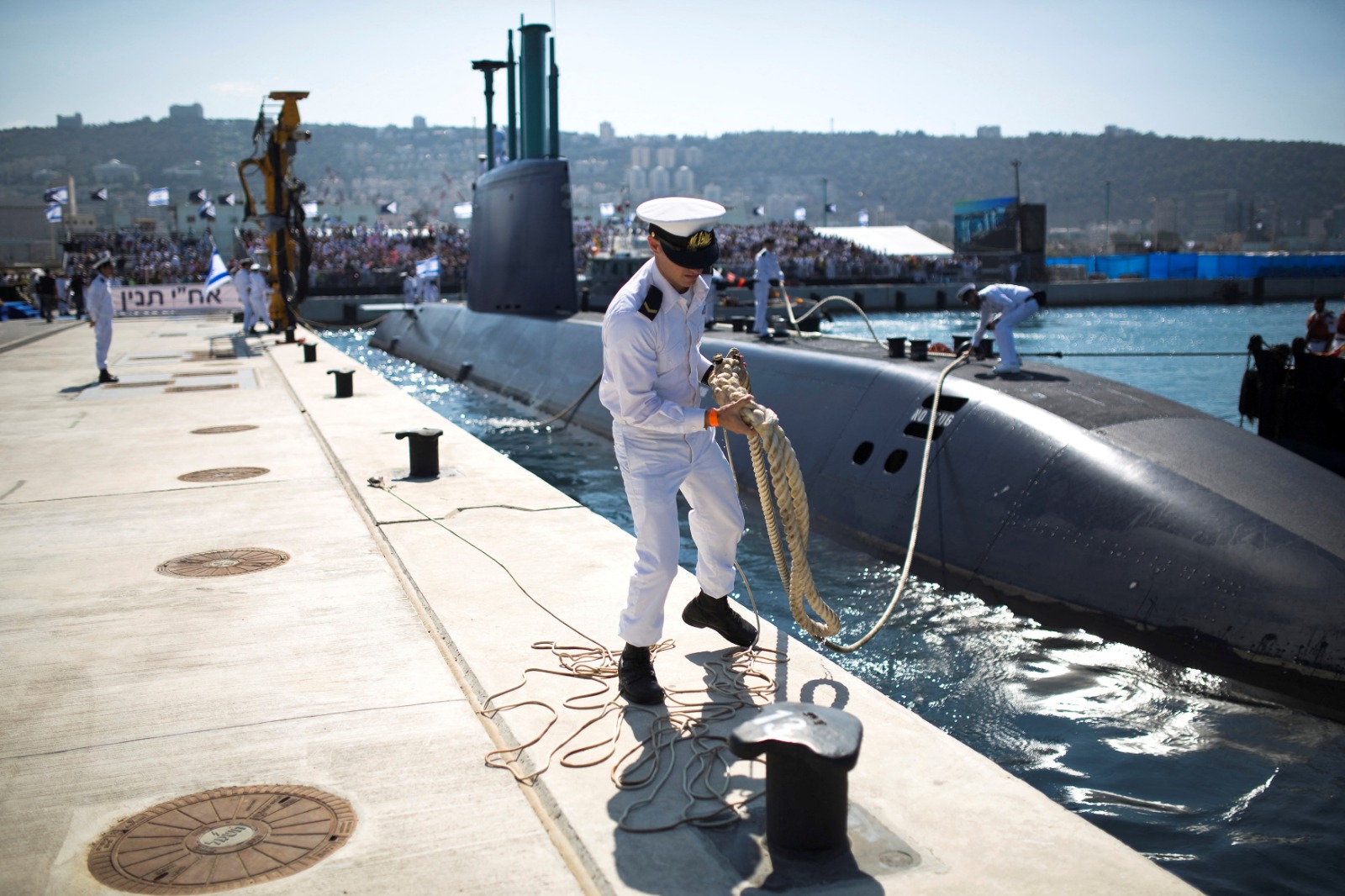 ضابط  في البحرية الإسرائيلية يمسك بحبل ربط الغواصة 'INS Tanin' ألمانية الصنع من طراز 'Dolphin AIP' أثناء رسوها في قاعدة بحرية بمدينة حيفا بعد وصولها إلى إسرائيل- 23 سبتمبر 2014