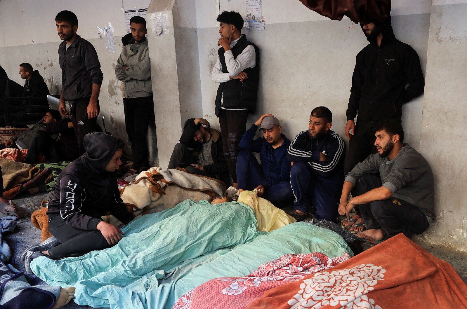 فلسطينيون أمام جثامين ذويهم خارج أحد مستشفيات غزة بعد سلسلة من الضربات الإسرائيلية. 18 مارس 2025