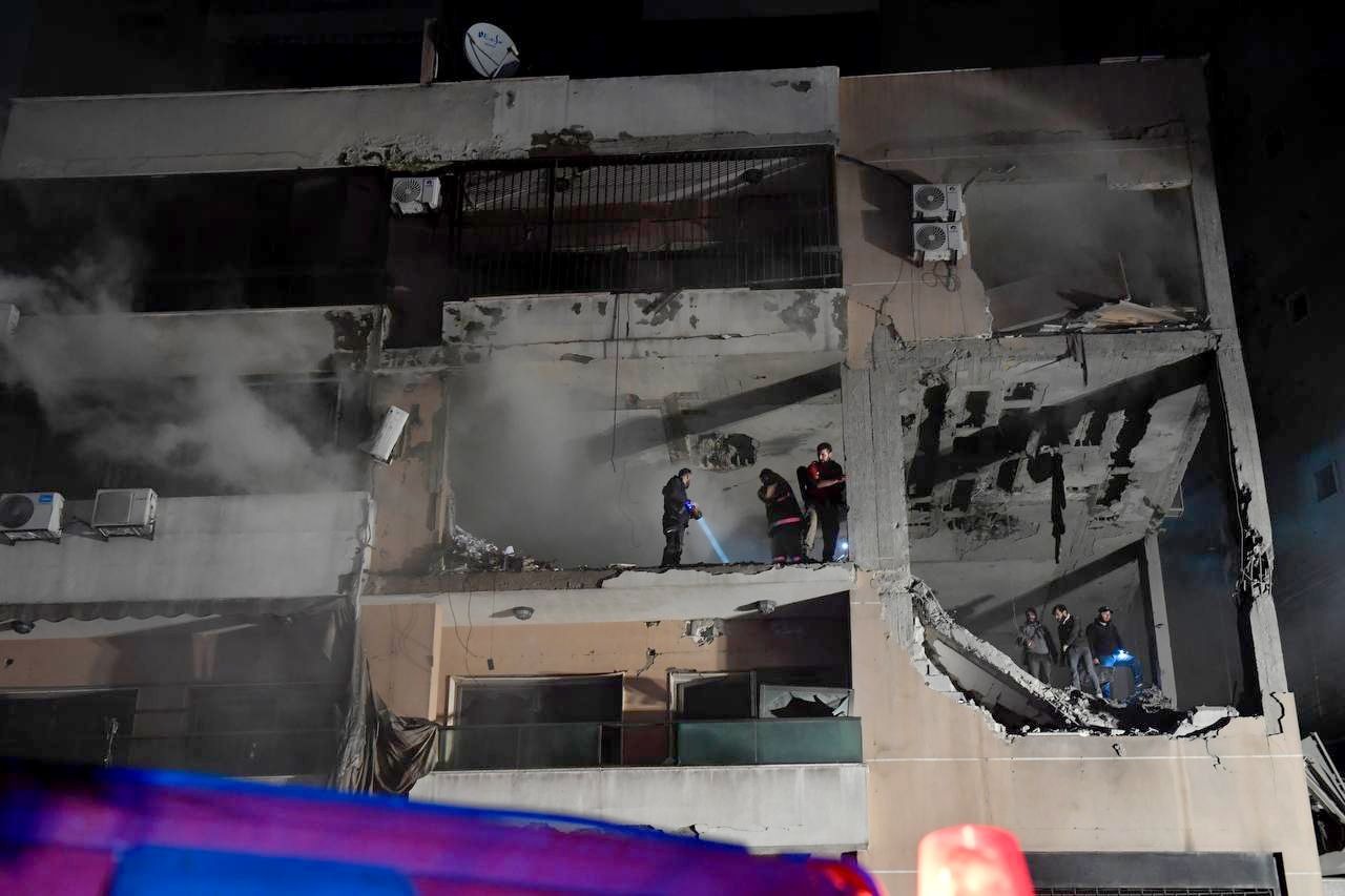 رجال الإنقاذ يبحثون عن ناجين داخل مبنى تعرض إلى أضرار كبيرة جرّاء قصف نفذته مسيرة إسرائيلية على الضاحية الجنوبية ببيروت. 2 يناير 2024