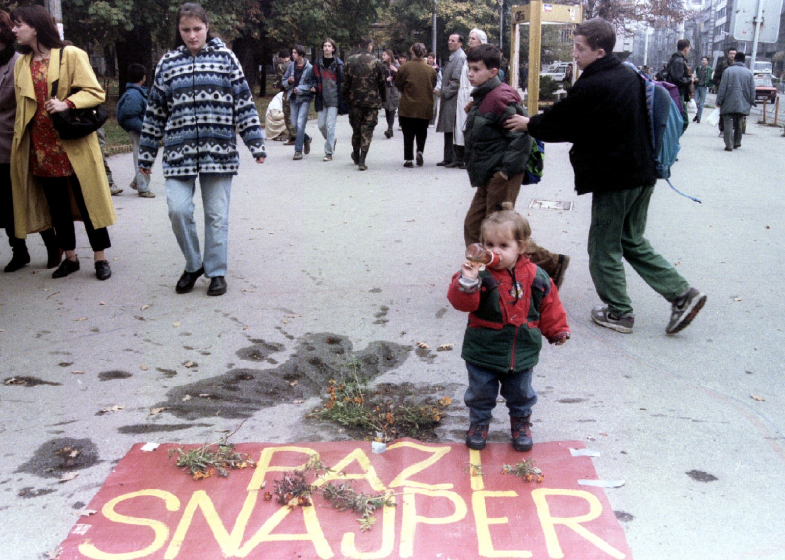 طفلة بوسنية تقف أمام لافتة مكتوب عليها احذروا قناصة في مديمو سراييفو. 2 نوفمبر 1995