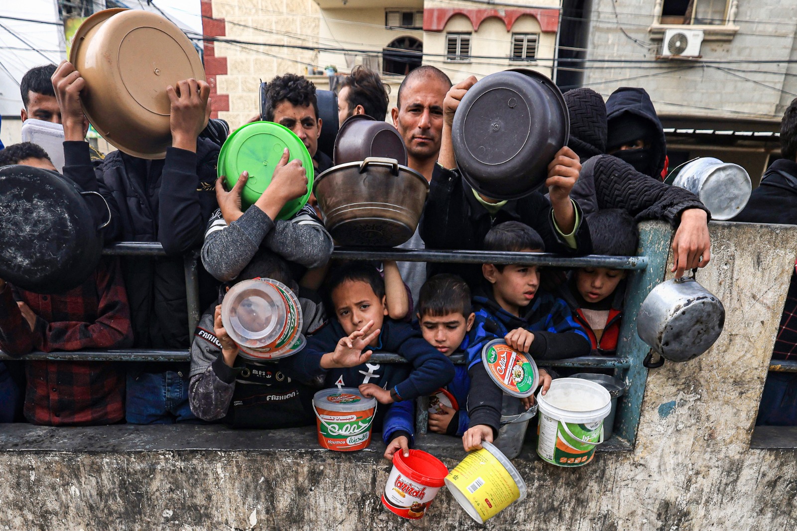 فلسطينيون ينتظرون لجمع الطعام عند نقطة تبرع في مخيم للاجئين في رفح بجنوب قطاع غزة. 23 ديسمبر 2023-