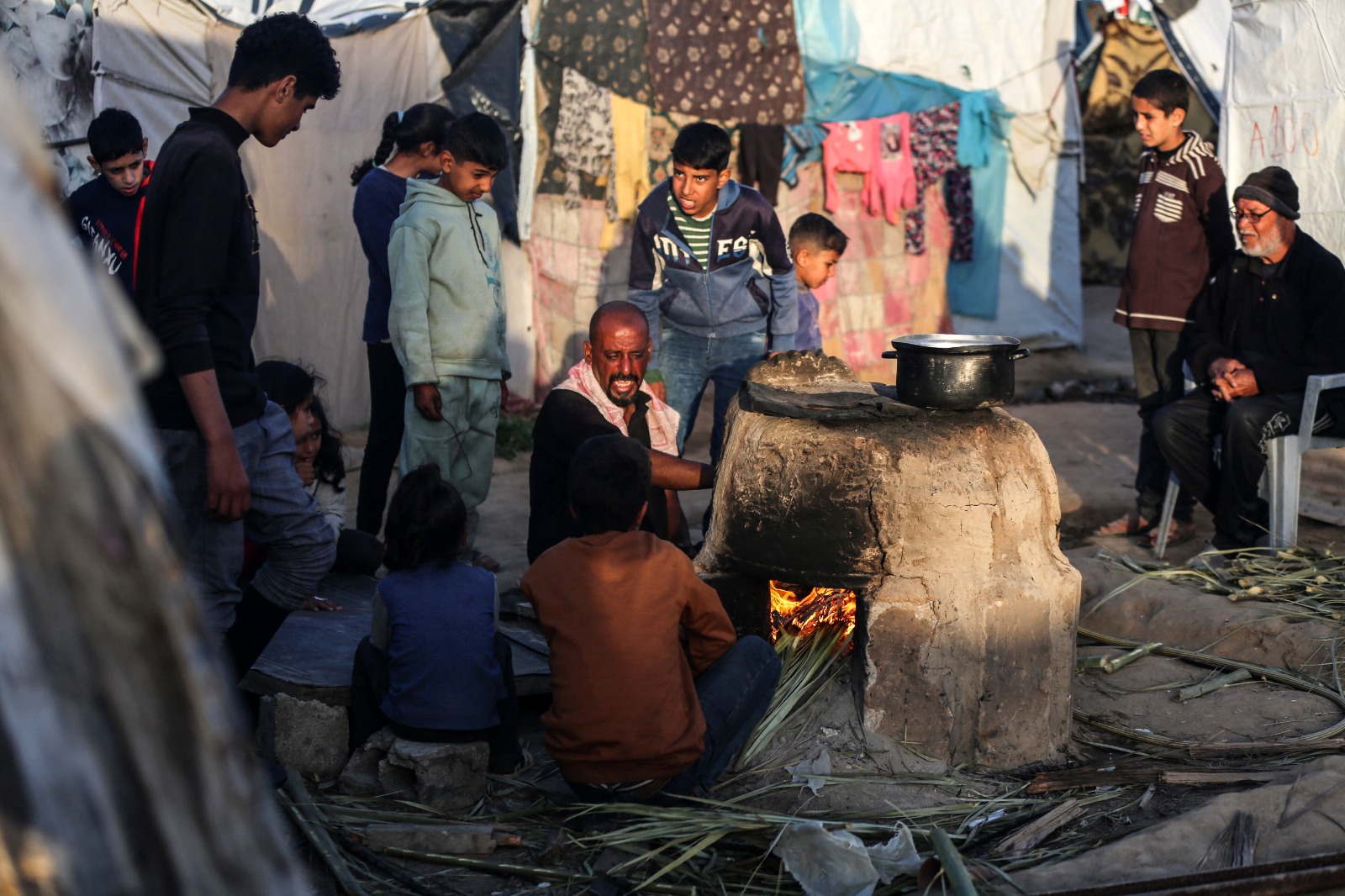 فلسطينيون يجتمعون في مخيم للنازحين بدير البلح بوسط قطاع غزة عشية شهر رمضان. 10 مارس 2024