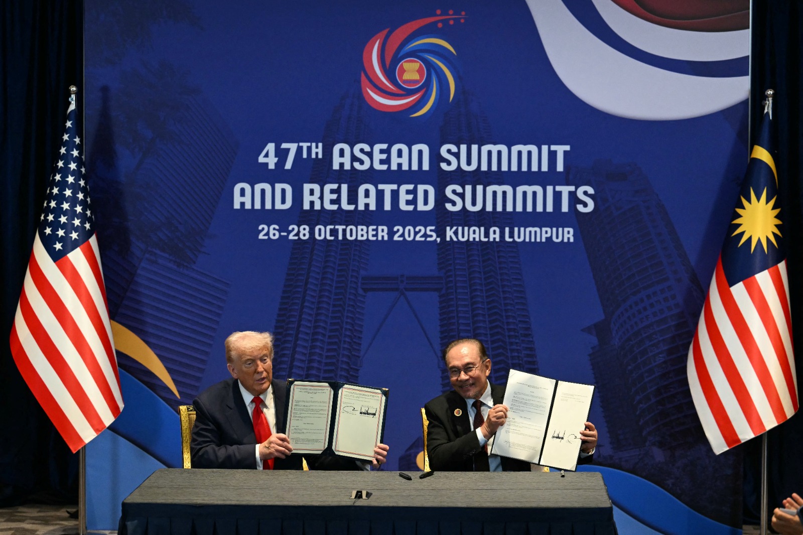 الرئيس الأميركي دونالد ترمب يوقع اتفاقاً مع رئيس الوزراء الماليزي أنور إبراهيم على هامش قمة رابطة دول جنوب شرق آسيا (آسيان) في العاصمة الماليزية كوالالمبور. 26 أكتوبر 2025