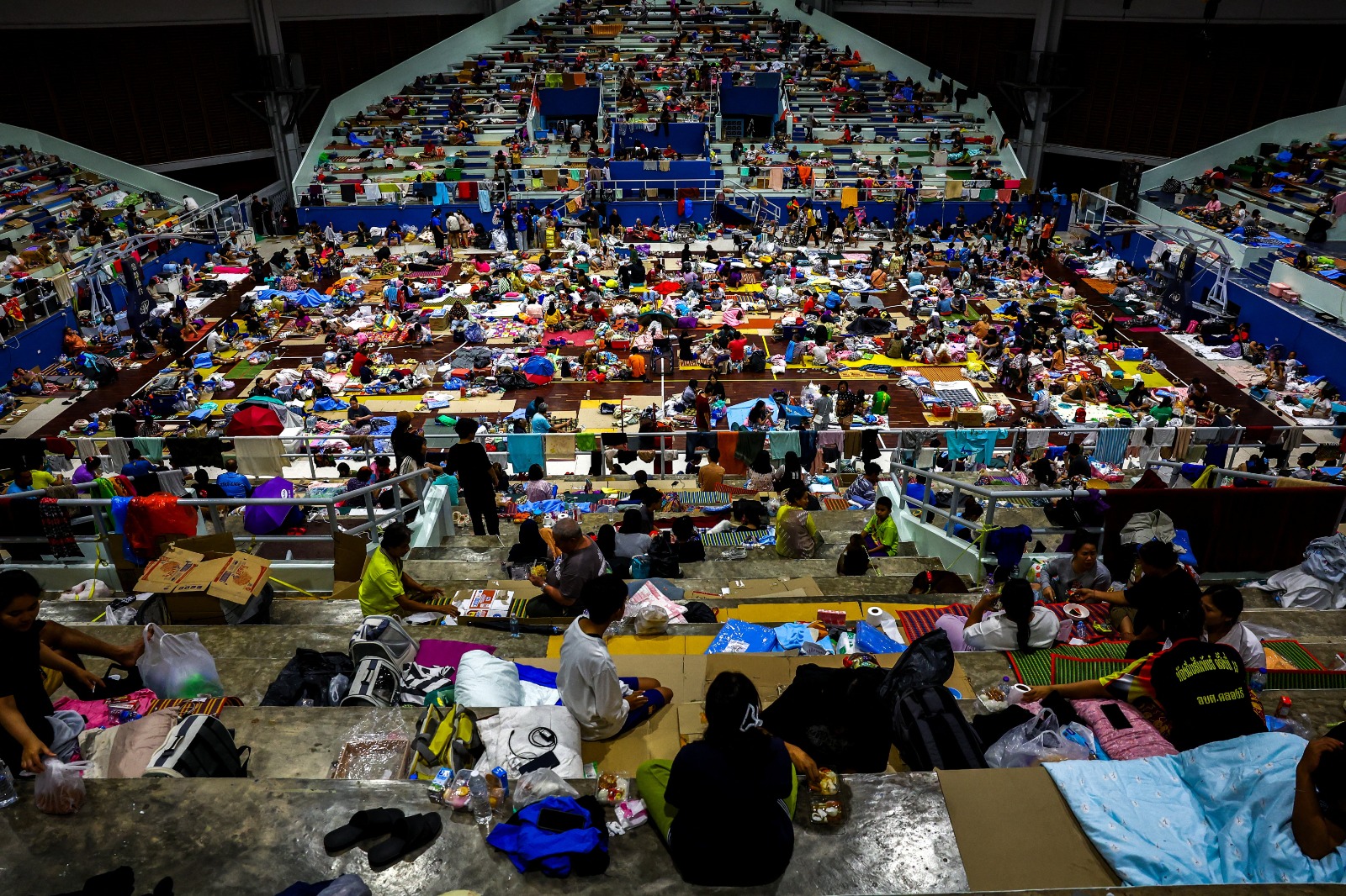 أشخاص يحتمون داخل ملجأ مؤقت بعد إجلائهم من مناطق غمرتها الفيضانات في منطقة هات ياي المتضررة من الأمطار الغزيرة التي أثرت على عدة مقاطعات في جنوب تايلندا. 26 نوفمبر 2025