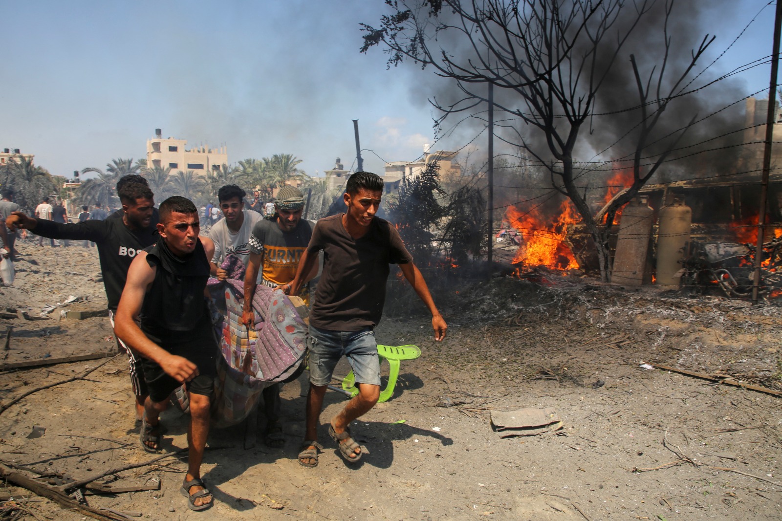 فلسطينيون يحملون جثمان شخص قتلته غارة إسرائيلية استهدفت مواصي خان يونس بجنوب قطاع غزة. 13 يوليو 2024