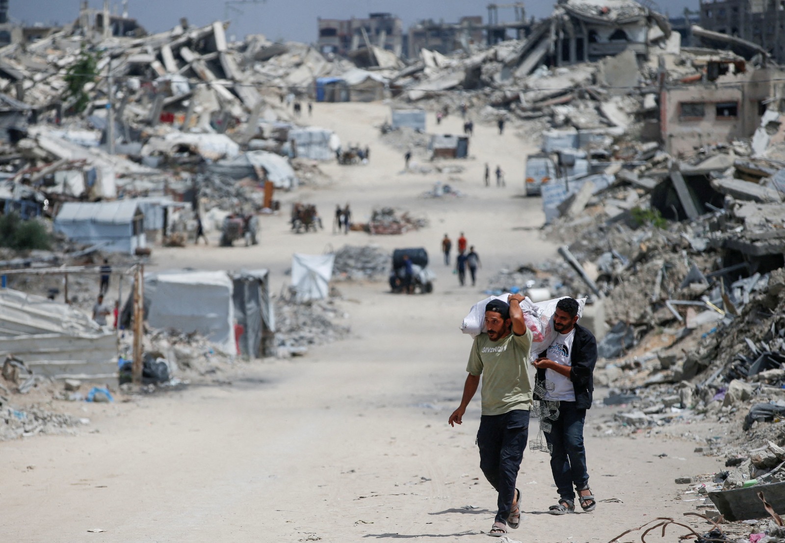 فلسطينيون يحملون أمتعتهم بعد إصدار الجيش الإسرائيلي أوامر الإخلاء من مناطق شمال قطاع غزة. 22 مايو 2025