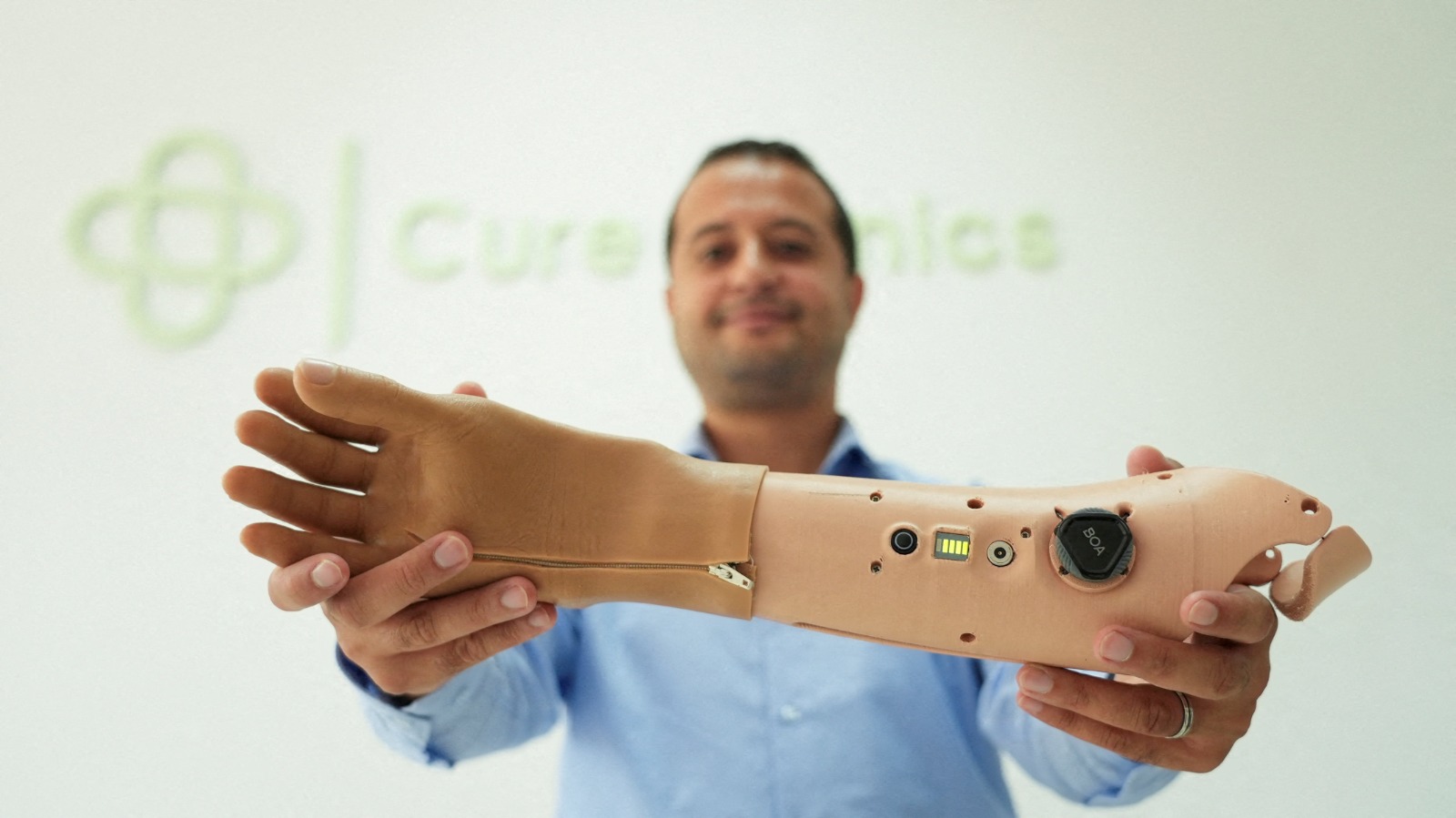 مؤسس شركة Cure Bionics والرئيس التنفيذي محمد الضوافي يلتقط صورة وهو يحمل اليد الاصطناعية هانيبال داخل المقر الرئيسي للشركة في سوسة بتونس. 5 أغسطس 2025
