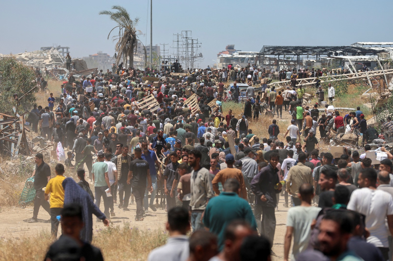 فلسطينيون بالقرب من موقع لـ'مؤسسة غزة الإنسانية' المدعومة من الولايات المتحدة في محاولة للحصول على المساعدات الغذائية. وسط غزة.، 29 مايو 2025