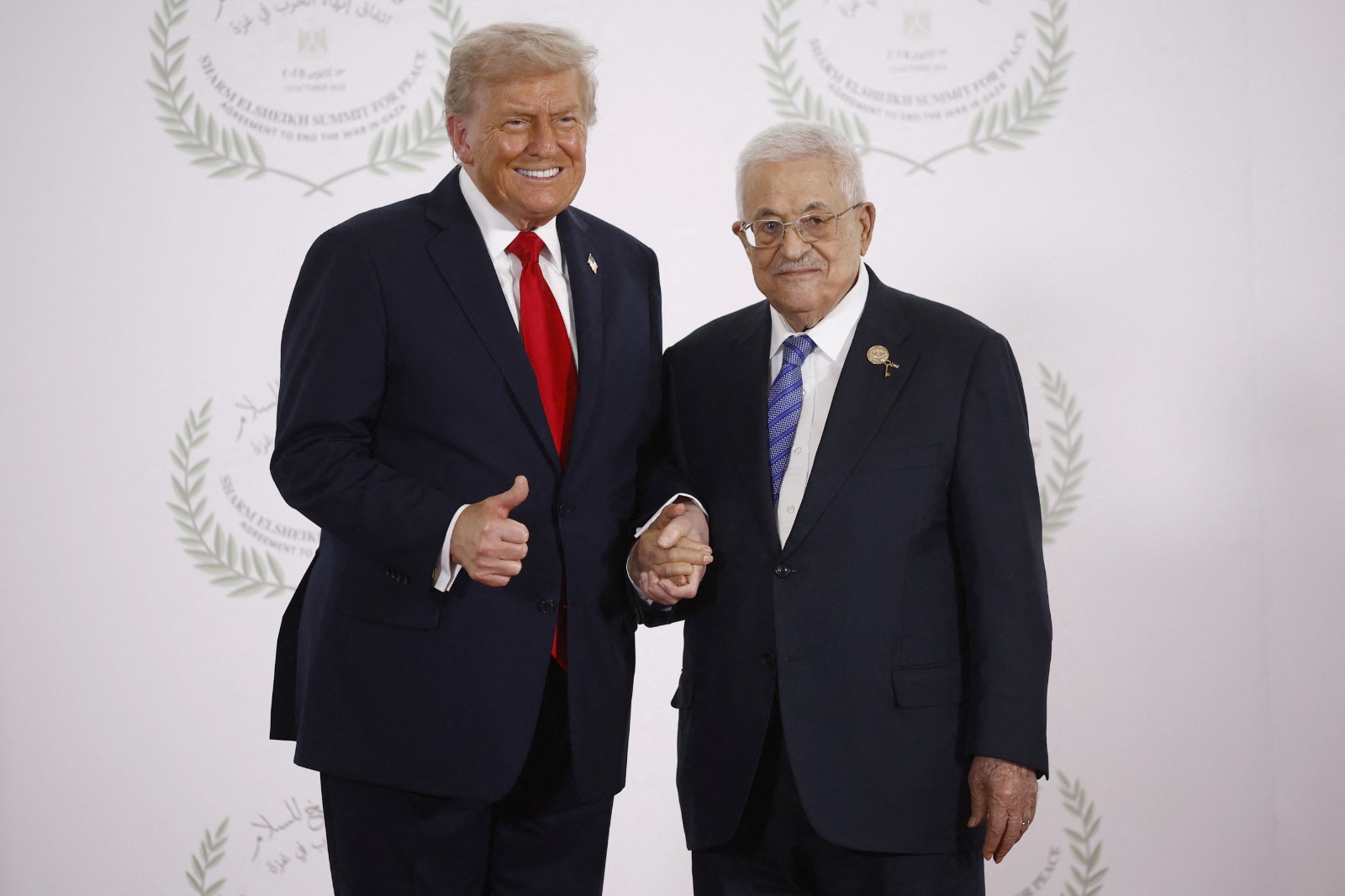 الرئيس الأميركي دونالد ترمب والرئيس الفلسطيني محمود عباس يلتقطان صورة في قمة زعماء العالم لإنهاء حرب غزة في شرم الشيخ بمصر. 13 أكتوبر 2025