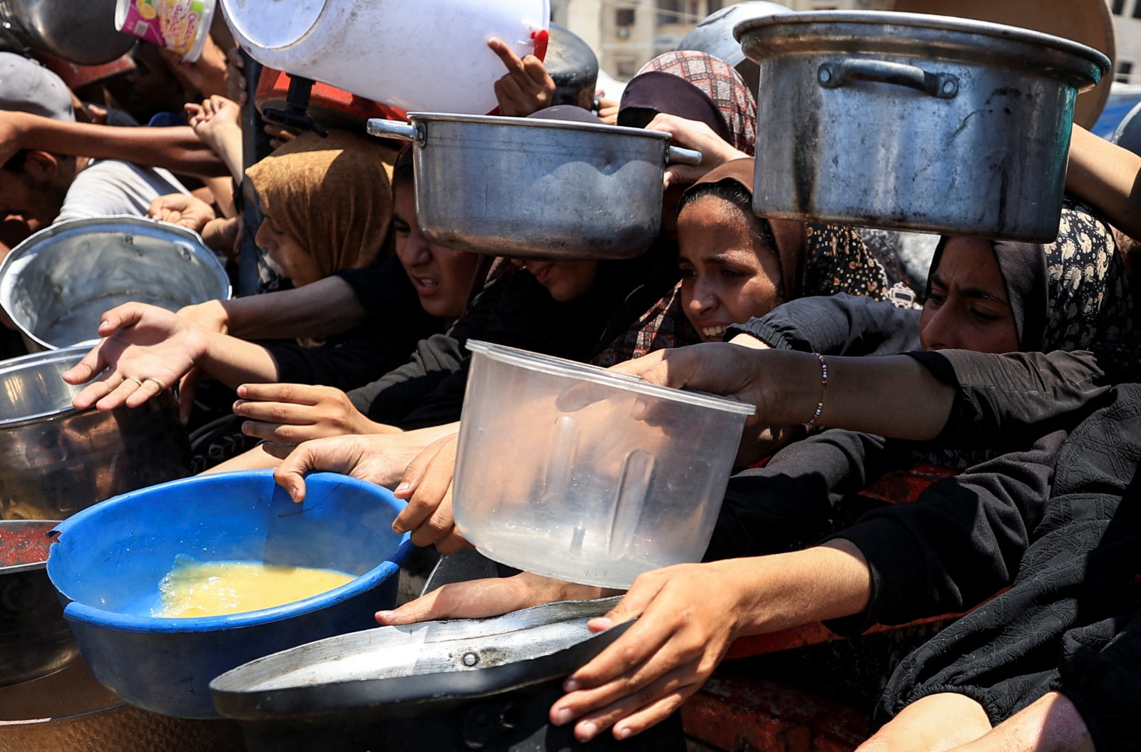 فلسطينيون يتجمعون لتلقي الطعام من مؤسسة خيرية في مدينة غزة. 24 يوليو 2025