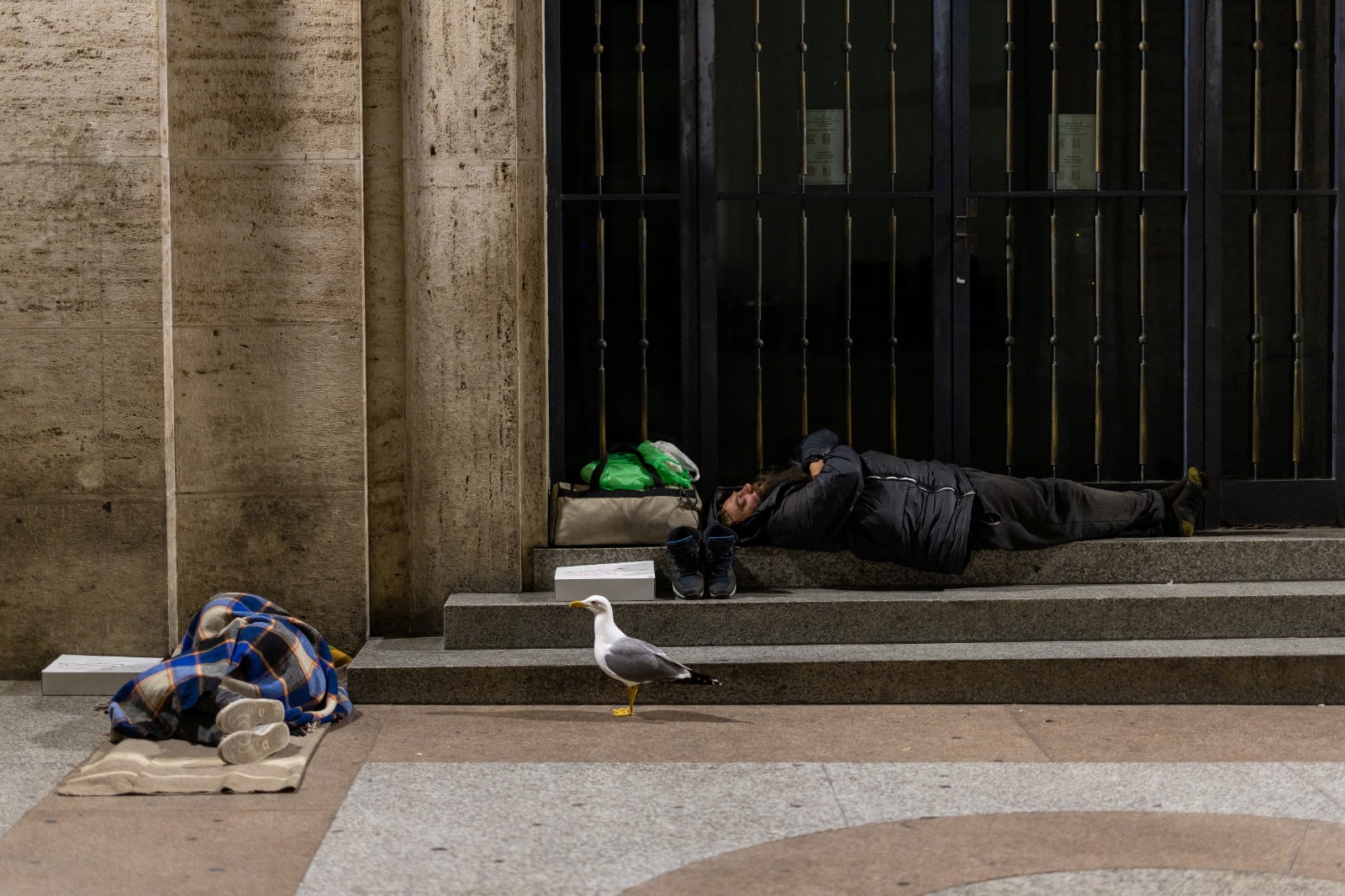 مشردان نائمان على رصيف بالقرب من كاتدرائية القديس بطرس في روما. إيطاليا في 25 أبريل 2025
