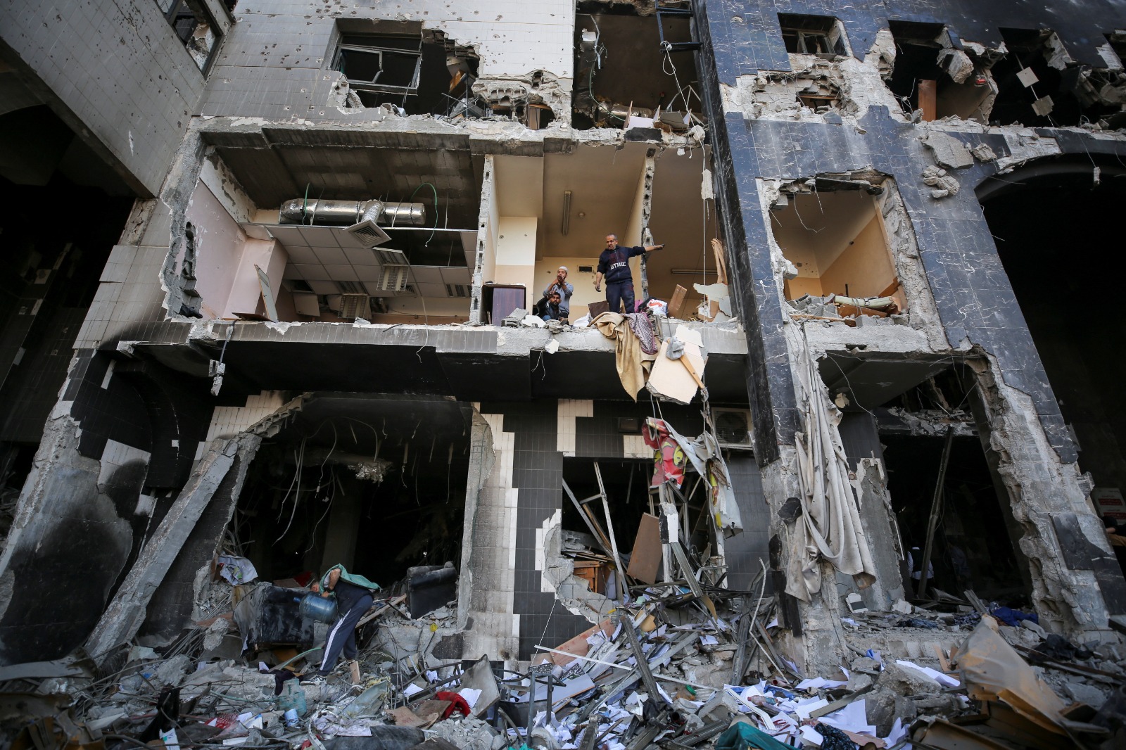 فلسطينيون يتفقدون أضرار مبنى الجراحة الخاصة في مستشفى الشفاء بعد انسحاب القوات الإسرائيلية. 1 أبريل 2024