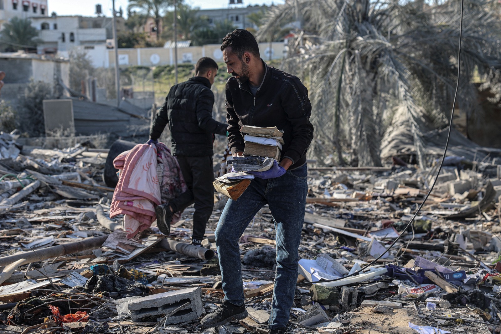 فلسطينيون يبحثون عن ممتلكاتهم في أول أيام رمضان وسط أنقاض منازل دمرها القصف الإسرائيلي في رفح جنوب قطاع غزة. 11 مارس 2024