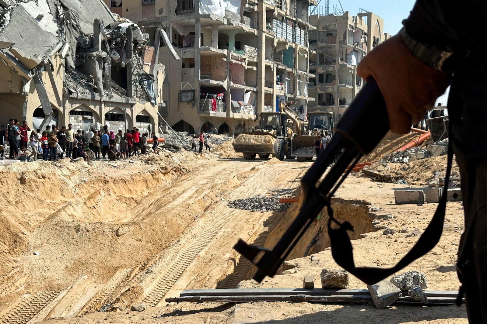 فلسطينيون يتجمعون بالقرب من موقع تجري فيه عمليات البحث عن جثث محتجزين إسرائيليين، خان يونس، جنوب قطاع غزة، 17 أكتوبر 2025