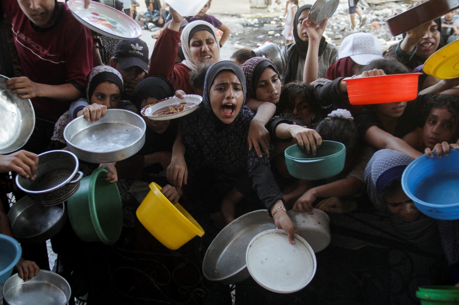 أطفال فلسطينيون أثناء محاولتهم الحصول على طعام من أحد المطابخ الخيرية في شمال قطاع غزة. 14 أغسطس 2024 - REUTERS