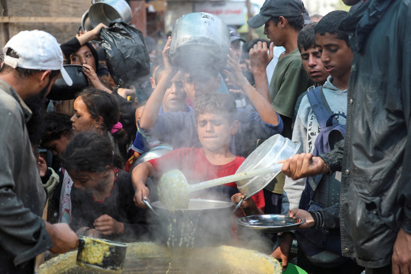 فلسطينيون يتجمعون للحصول على طعام من مطبخ خيري في دير البلح وسط قطاع غزة. 10 نوفمبر 2024