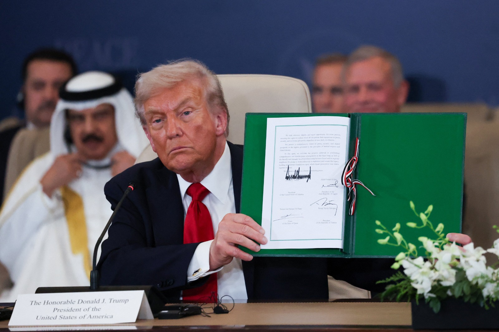 الرئيس الأميركي دونالد ترمب يرفع وثيقة اتفاق وقف الحرب في غزة عقب التوقيع عليها، شرم الشيخ. 13 أكتوبر 2025