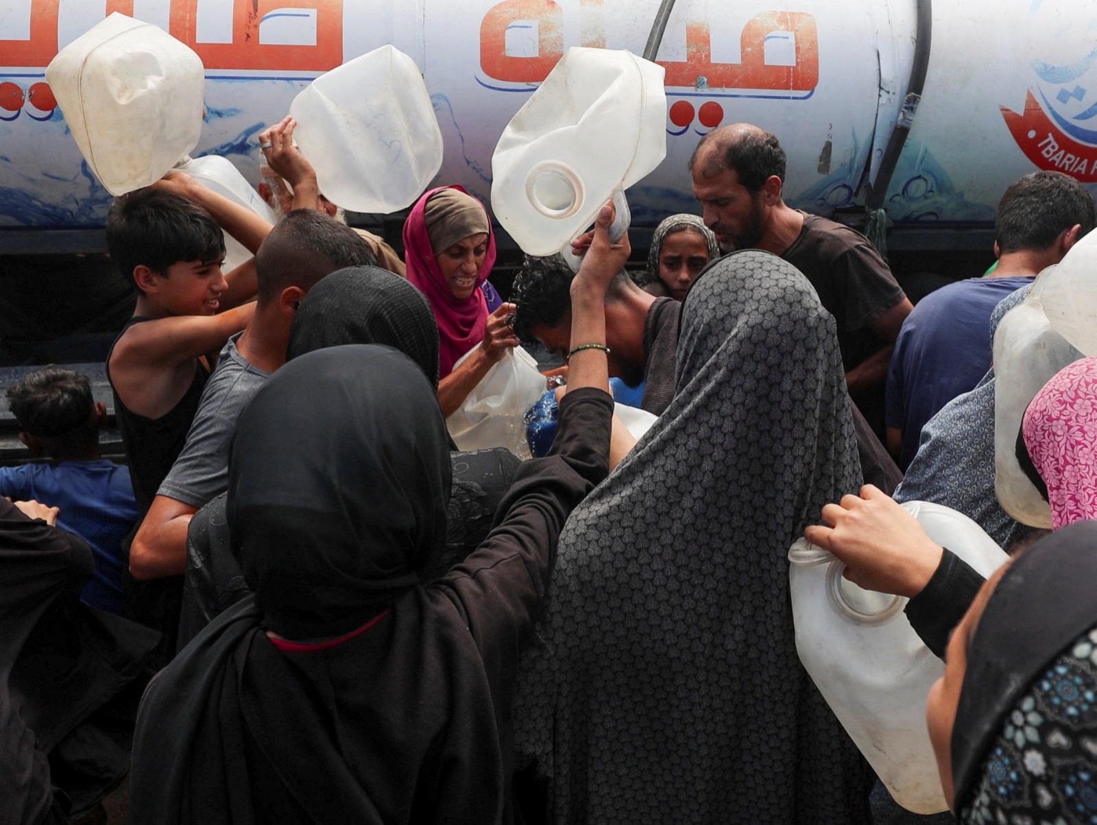 فلسطينيون نازحون يتجمعون للحصول على المياه في مخيم بمدينة غزة. 1 أغسطس 2025
