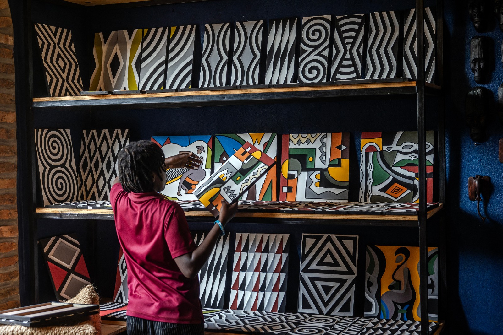 عامل يعرض قطعا من فن روث البقر التقليدي إيميجونجو داخل متجر لبيع الفن والحرف اليدوية الإفريقية التقليدية في كايونزا برواندا. 4 أبريل 2024