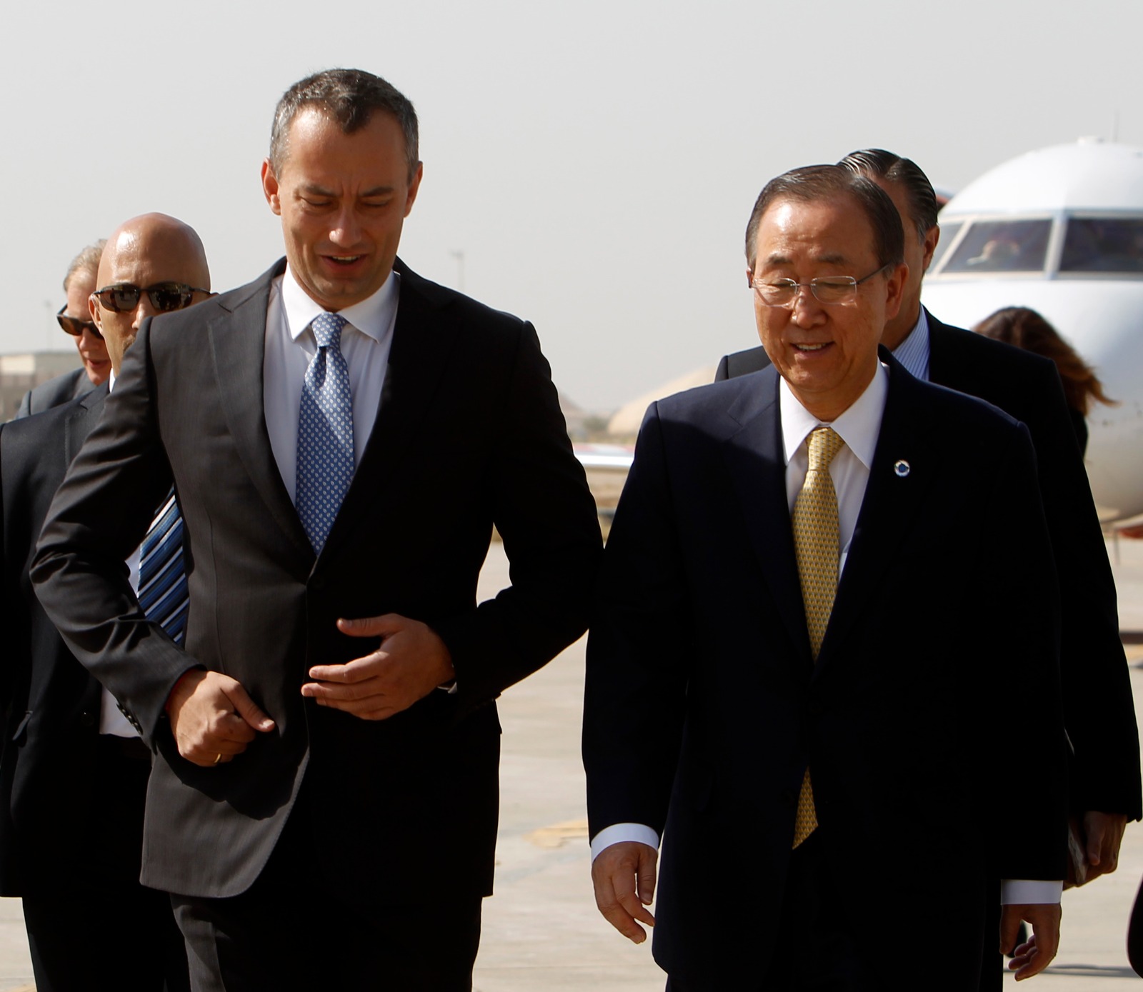 الأمين العام السابق للأمم المتحدة بان كي مون (يمين) يسير مع نيكولاي ملادينوف الممثل الأممي للعراق حينها في مطار بغداد. 24 يوليو 2014