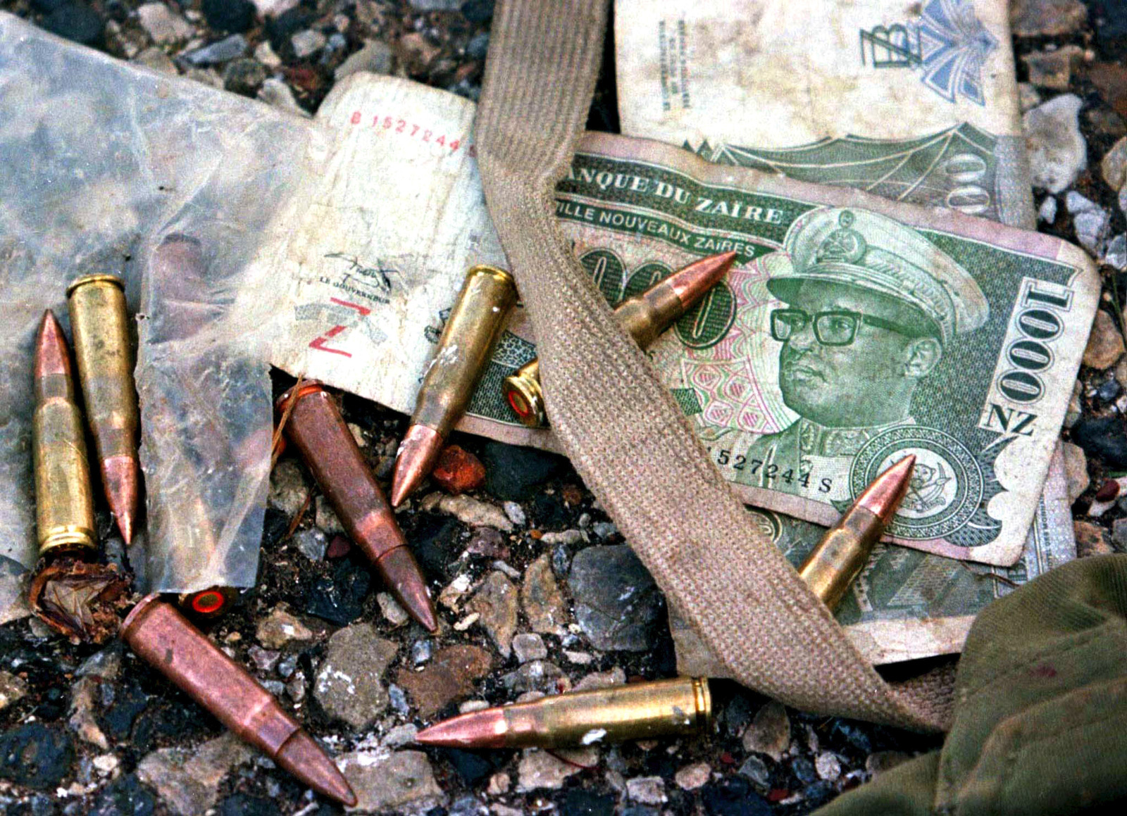 أوراق نقدية تحمل صورة الرئيس الزائيري الراحل موبوتو سيسي سيكو تتناثر فوقها رصاصات من رشاش سوفيتي الصنع- 1 يناير 2003