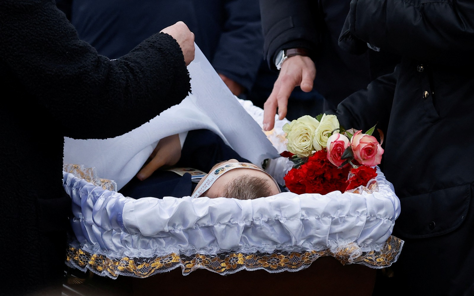 والدة المعارض الروسي أليكسي نافالني تغطي جثمانه خلال مراسم دفن ابنها في موسكو. 1 مارس 2024