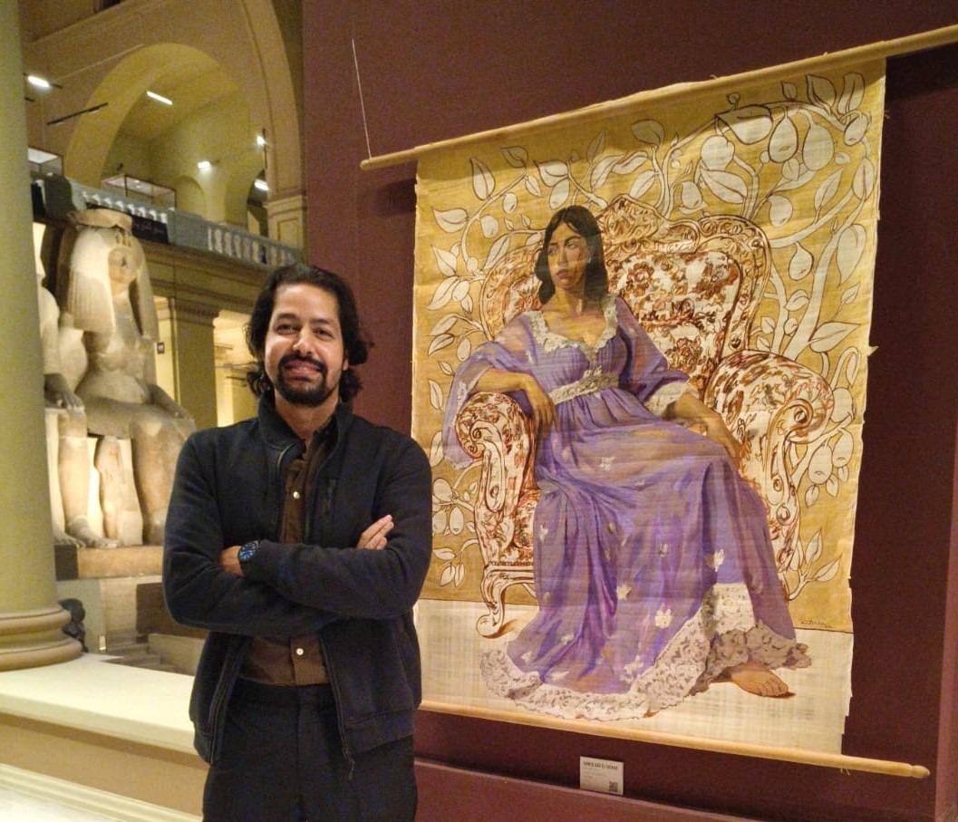 فنان مصري إلى جانب لوحته