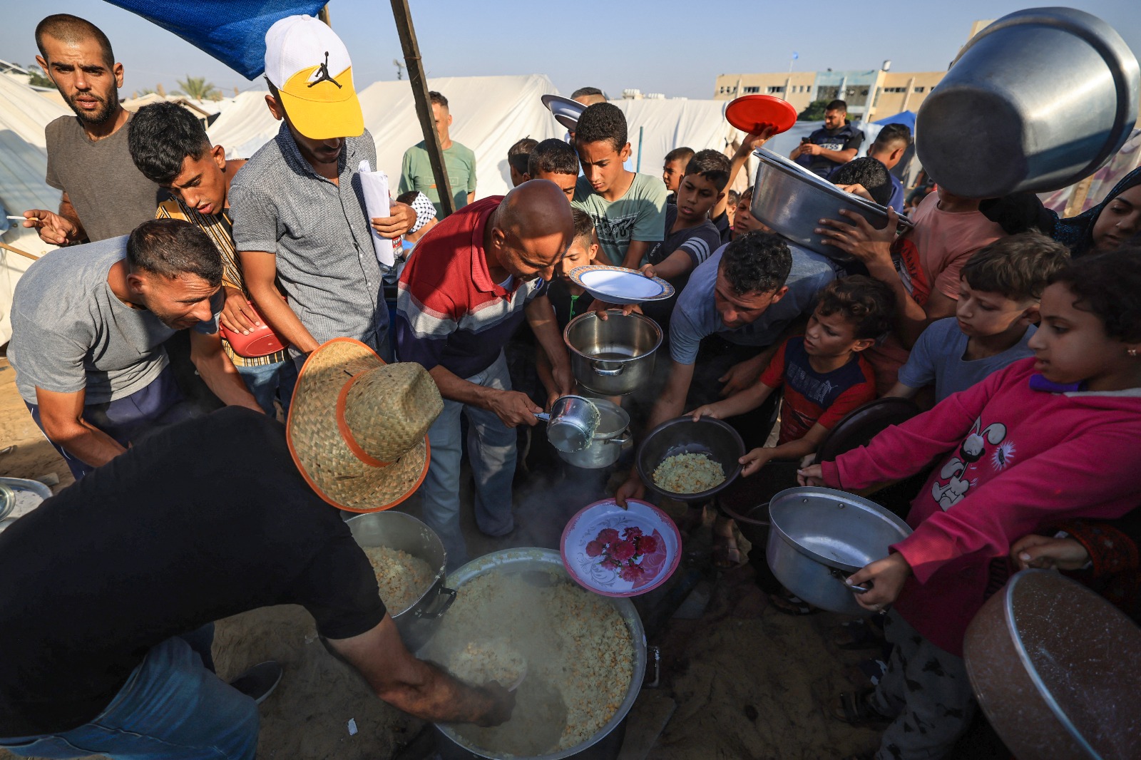 نازحون فلسطينيون من شمال غزة يوزعون الطعام في مخيم 