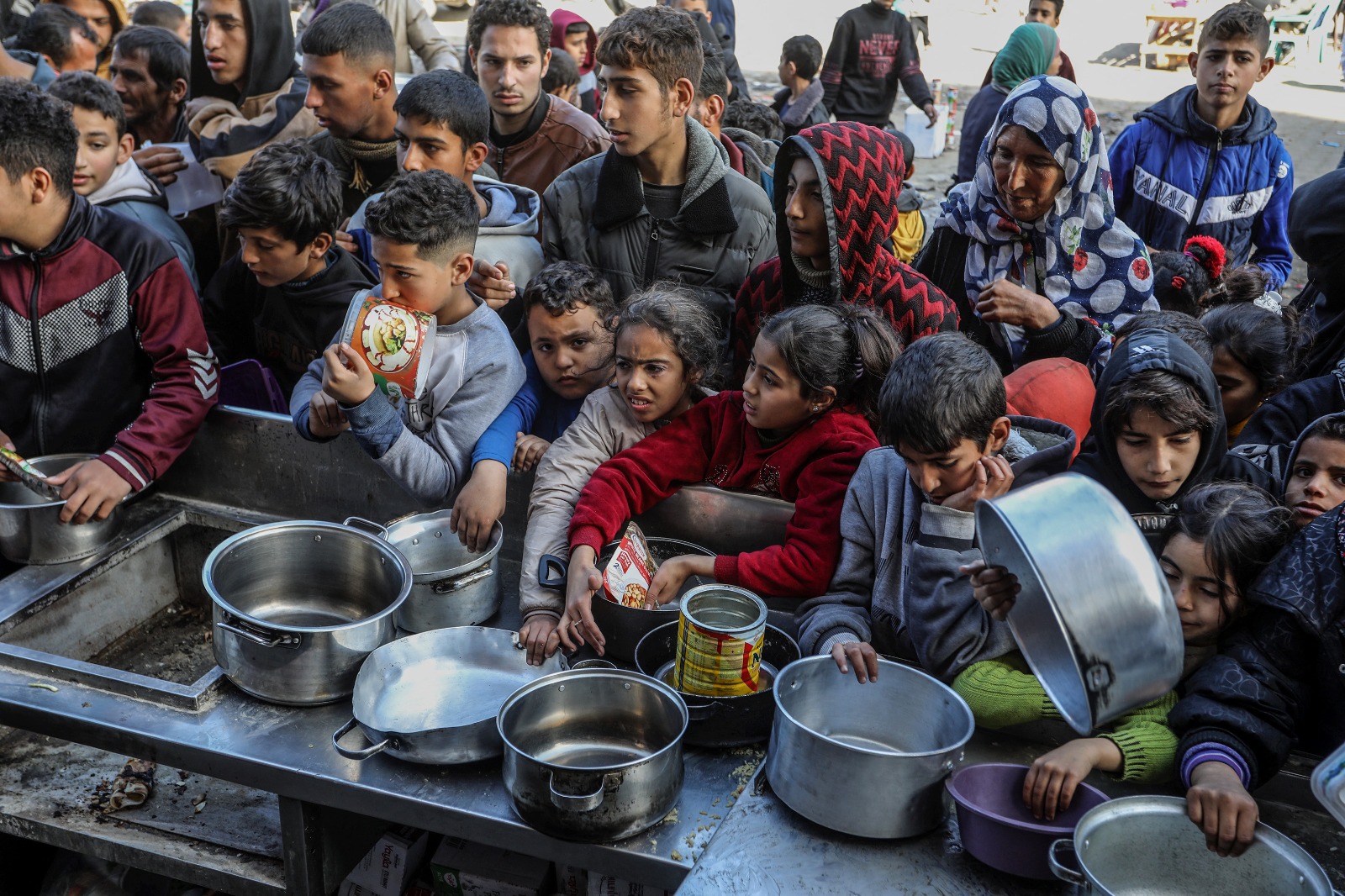 فلسطينيون يحملون أوعية فارغة انتظاراً للحصول على الطعام مع استمرار الهجمات الإسرائيلية في رفح، غزة. 26 يناير 2024