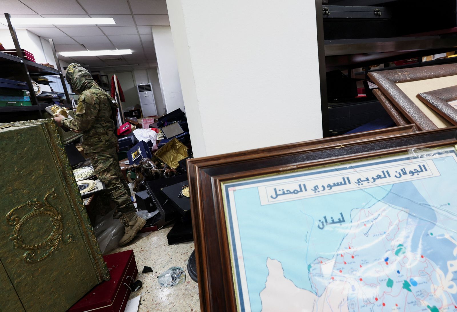 A rebel fighter looks at personal souvenirs of Syria's Bashar al-Assad at one of the rooms at Presidential Palace known as Qasr al-Shaab 'People's Palace', after rebels seized the capital and ousted Syria's Bashar al-Assad, in Damascus, Syria December 10, 2024. REUTERS/Amr Abdallah Dalsh