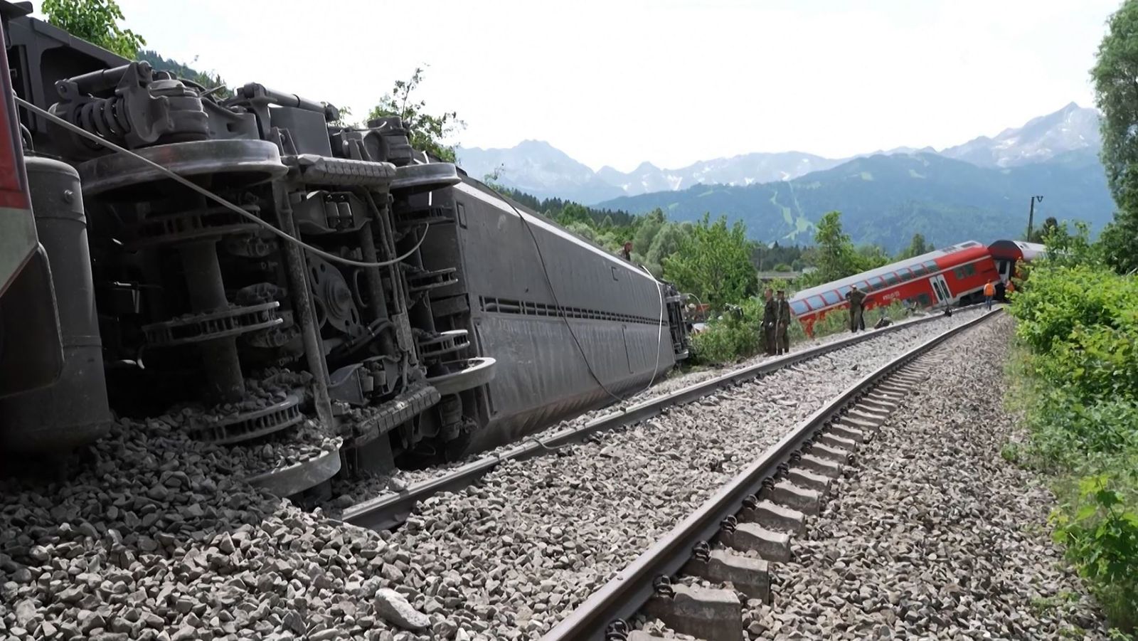 This video grab taken from footage of Network Pictures on June 3, 2022 shows rescue services at the site of a derailed train near Burgrain near Garmisch-Partenkirchen, southern Germany. - At least three people were killed and several others injured as a train derailed near a Bavarian Alpine resort in southern Germany on June 3, police said. 
