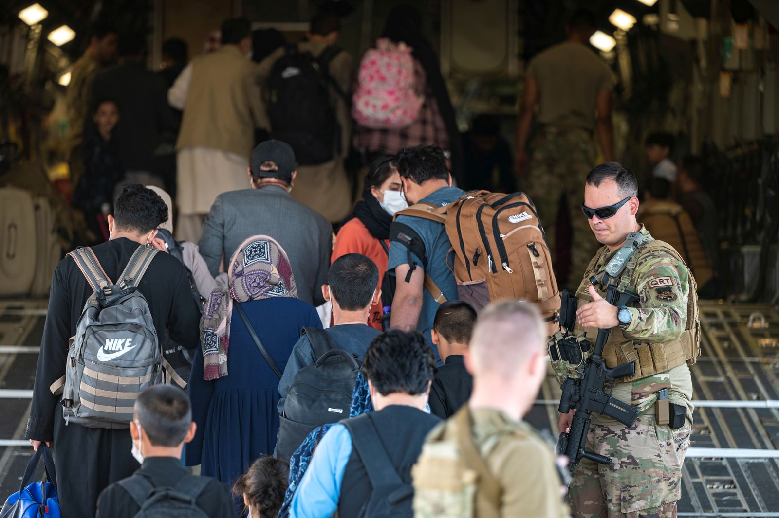 جندي أميركي يسهّل دخول أفراد إلى طائرة عسكرية تمهيداً لإجلائهم من مطار كابول - 24 أغسطس 2021 - REUTERS
