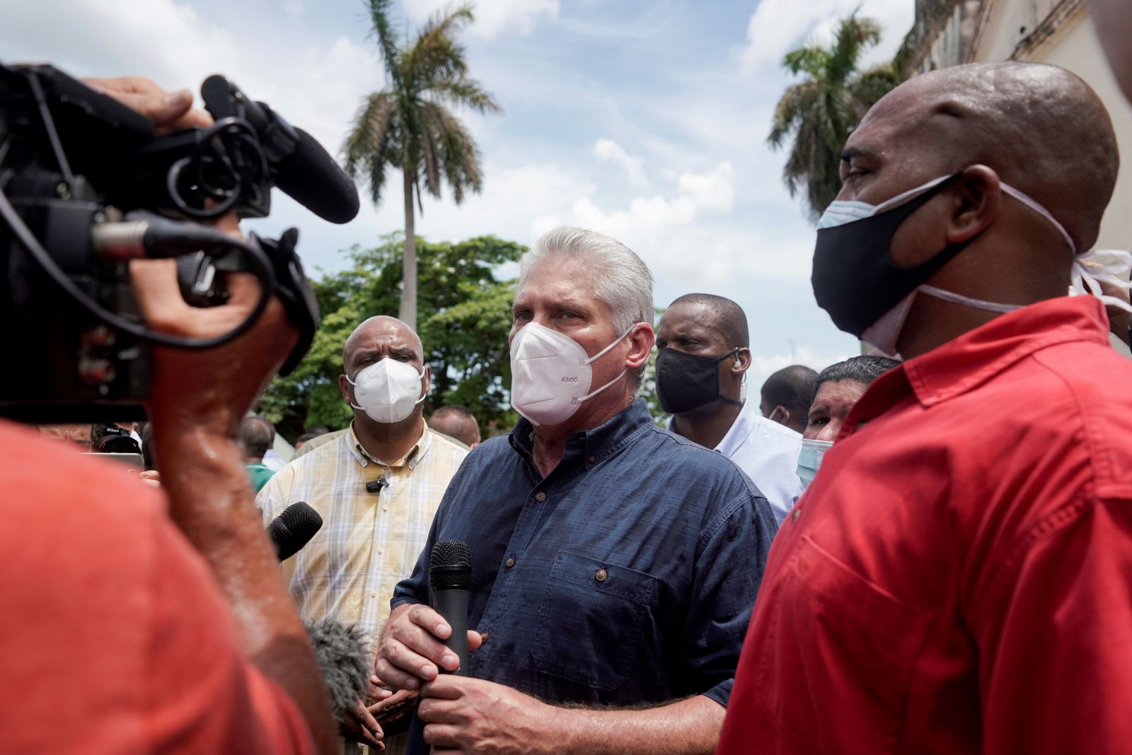 الرئيس الكوبي ميغيل دياز كانيل (وسط) خلال زيارته بلدة سان أنطونيو دي لوس بانيوس التي شهدت احتجاجات - 11 يوليو 2021 - REUTERS